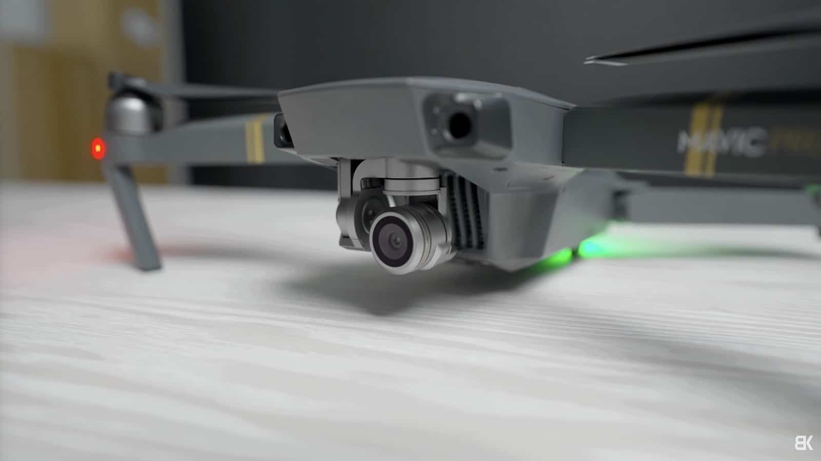 Original Mavic Pro on a table, its arm label and green status light visible.