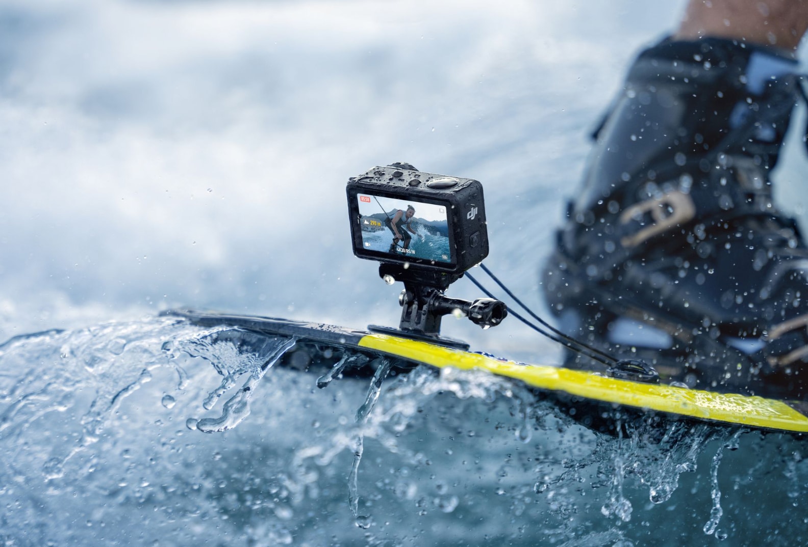 Camera mounted on the nose of a yellow board as spray washes over it.
