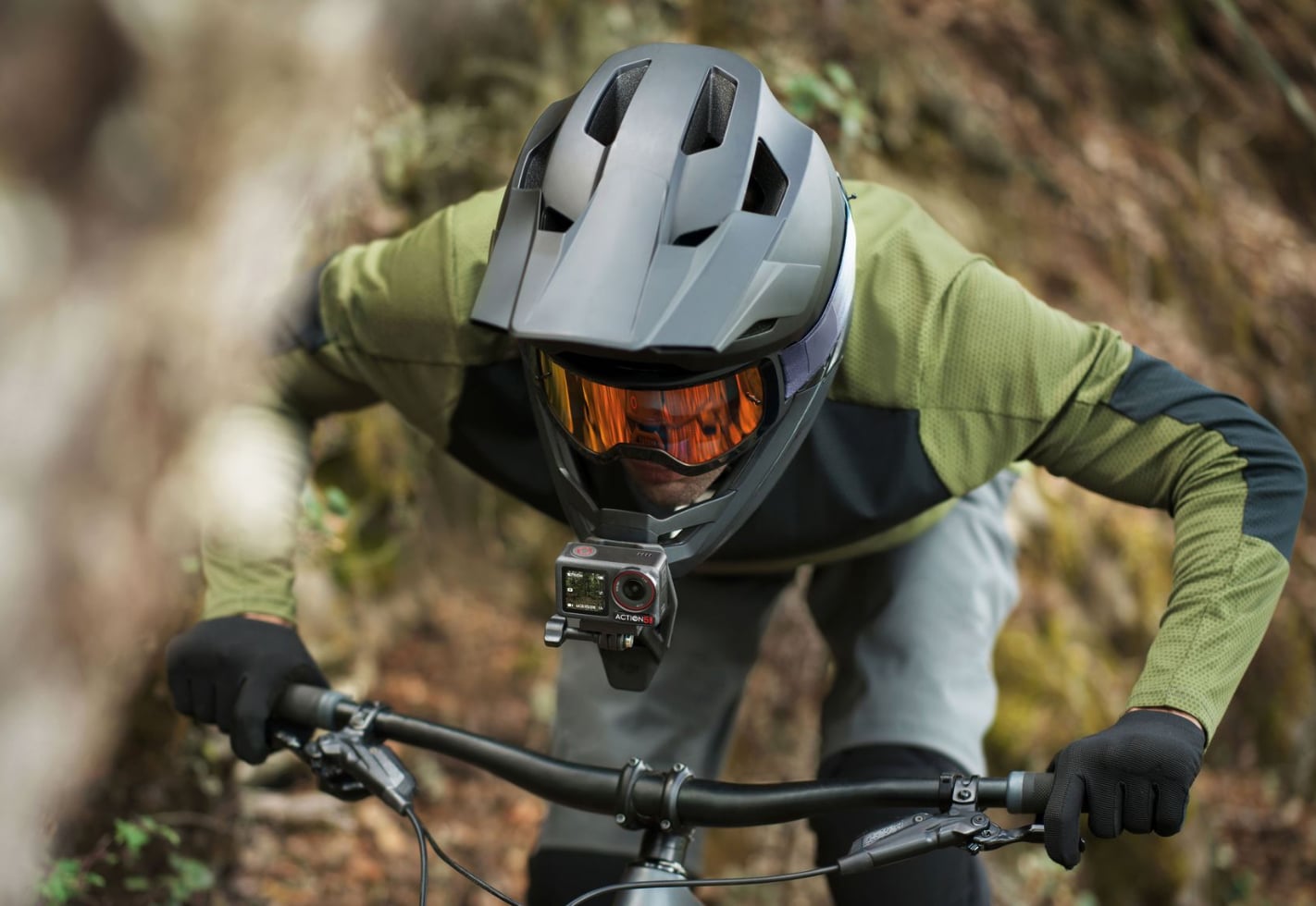 Mountain biker in a full-face helmet with the camera strapped to his chest.