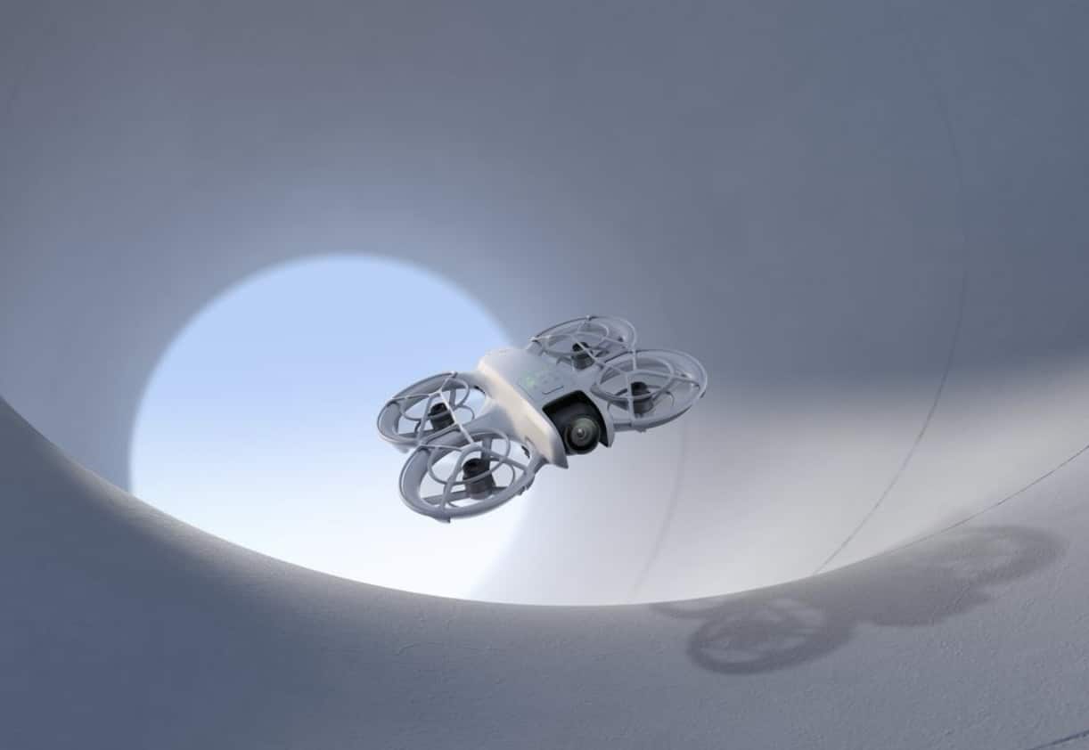 The Neo hovers inside a white curved interior, its shadow cast on the wall.
