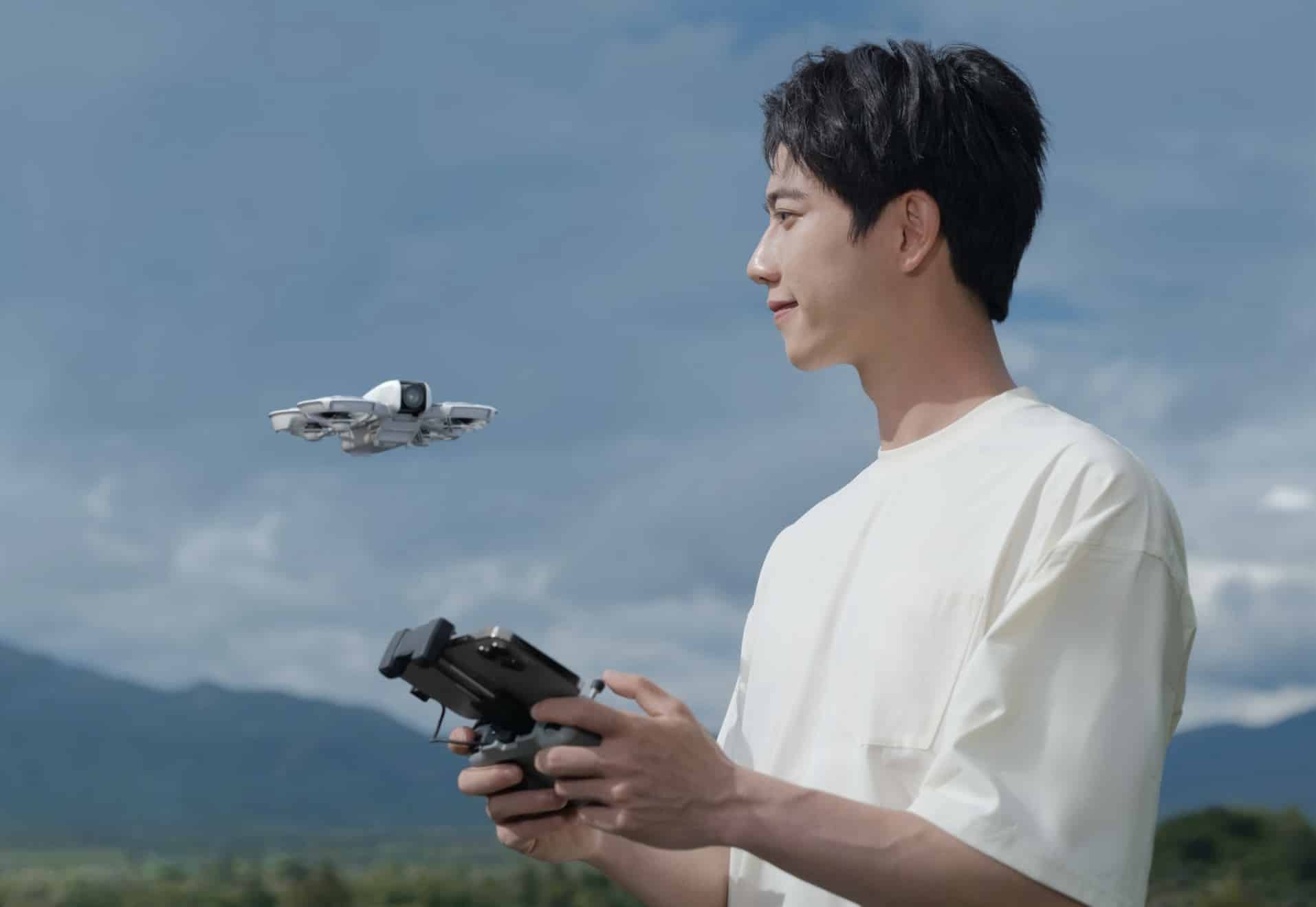 A pilot flies the Neo with the DJI RC-N controller in open countryside.