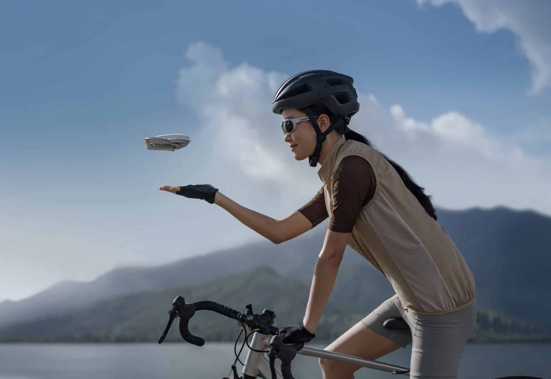A cyclist reaches out a gloved hand to catch the returning Neo.