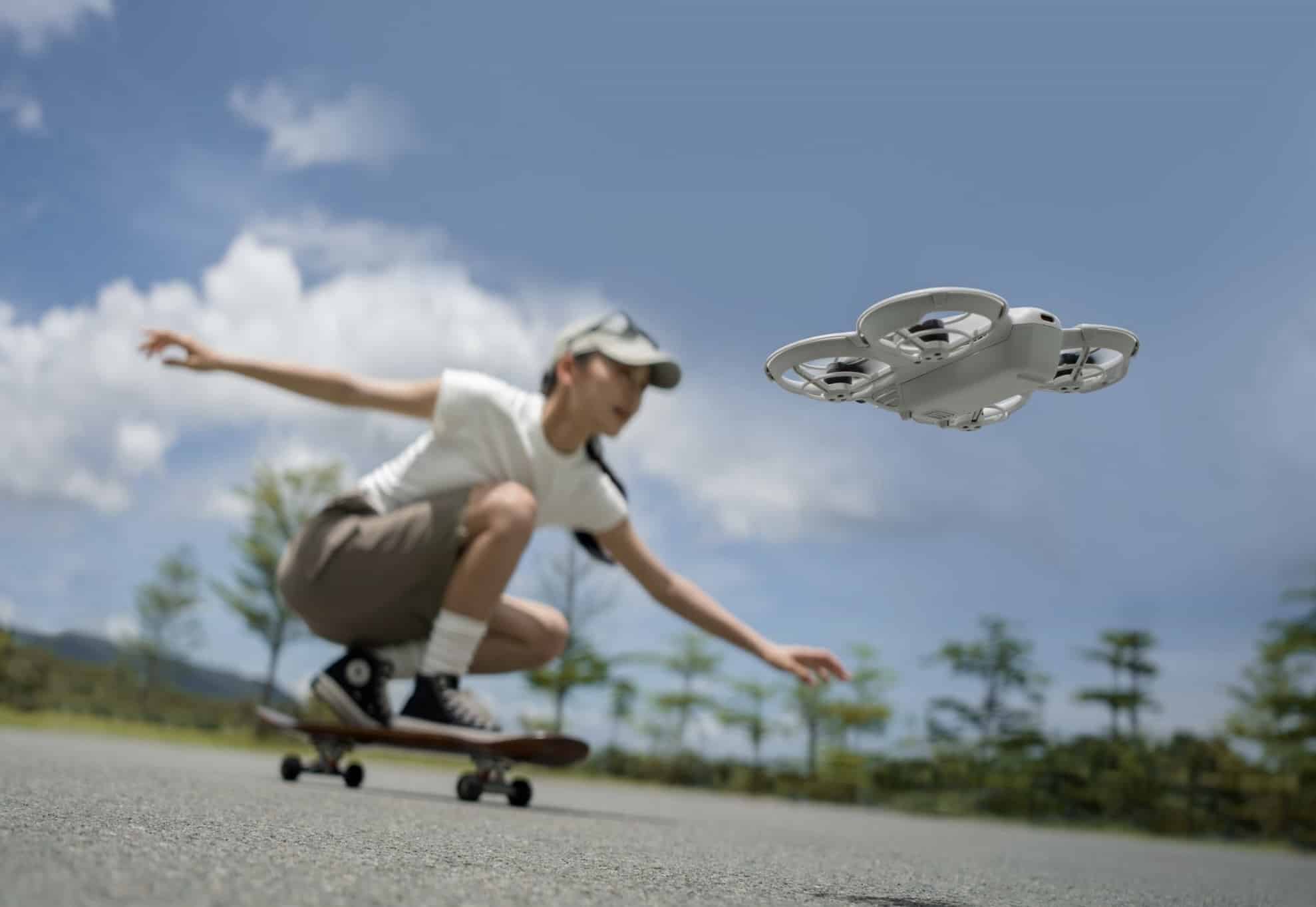 A skateboarder crouches into a turn as the Neo trails just behind him.