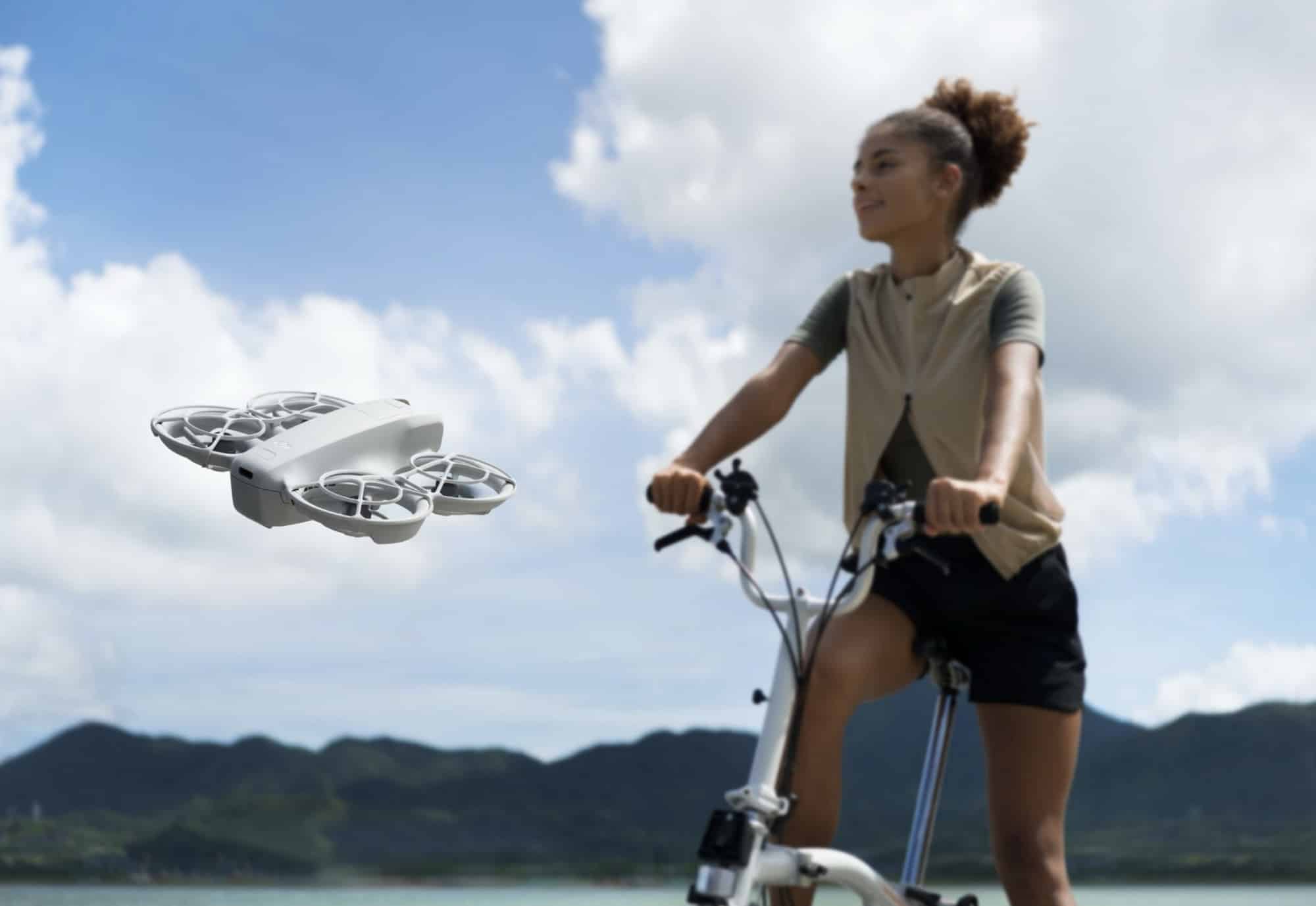 The Neo hovers level with a woman pausing on her folding bike by a lake.