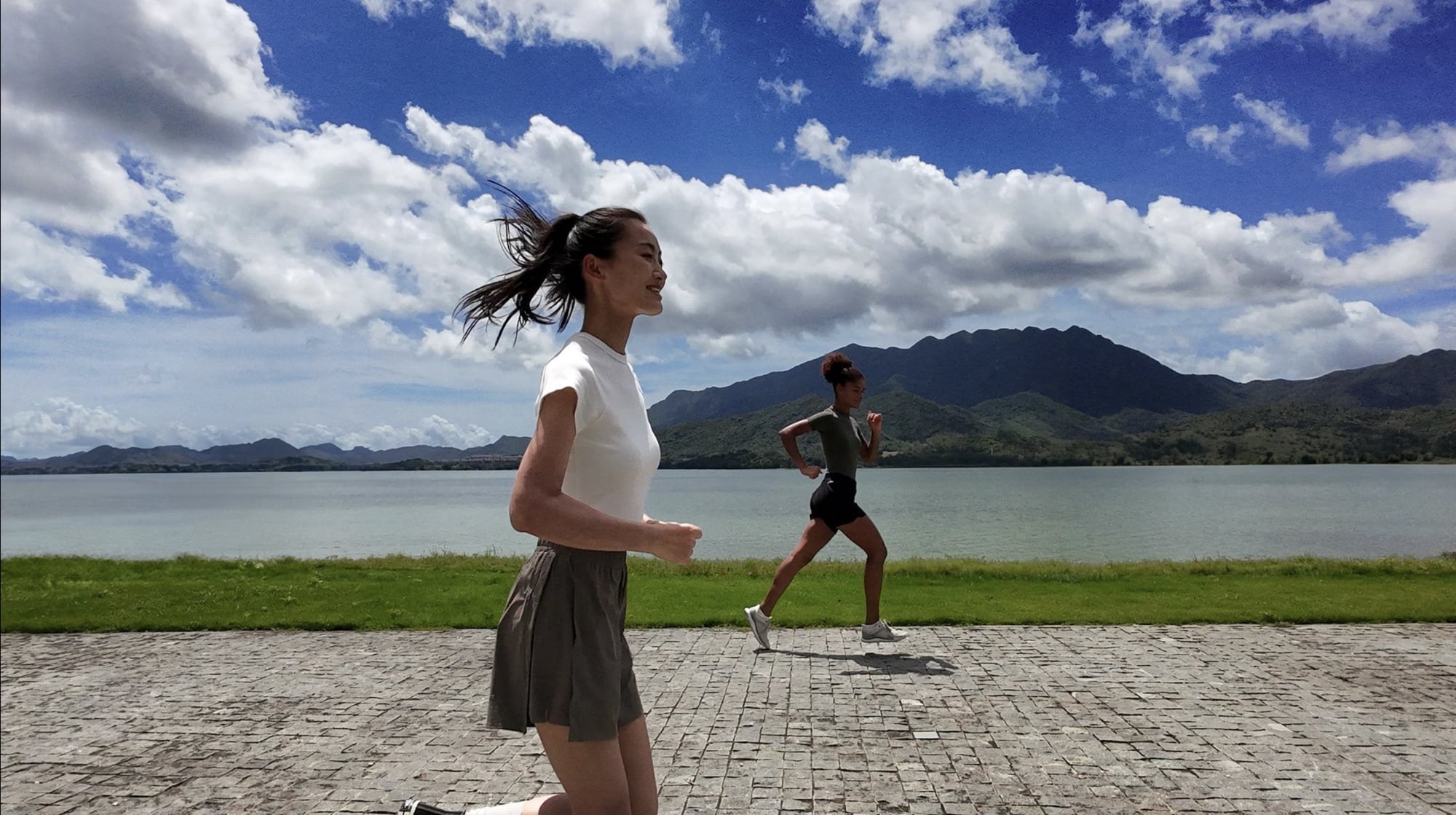 Two runners on a lakeside promenade captured from the Neo at low altitude.