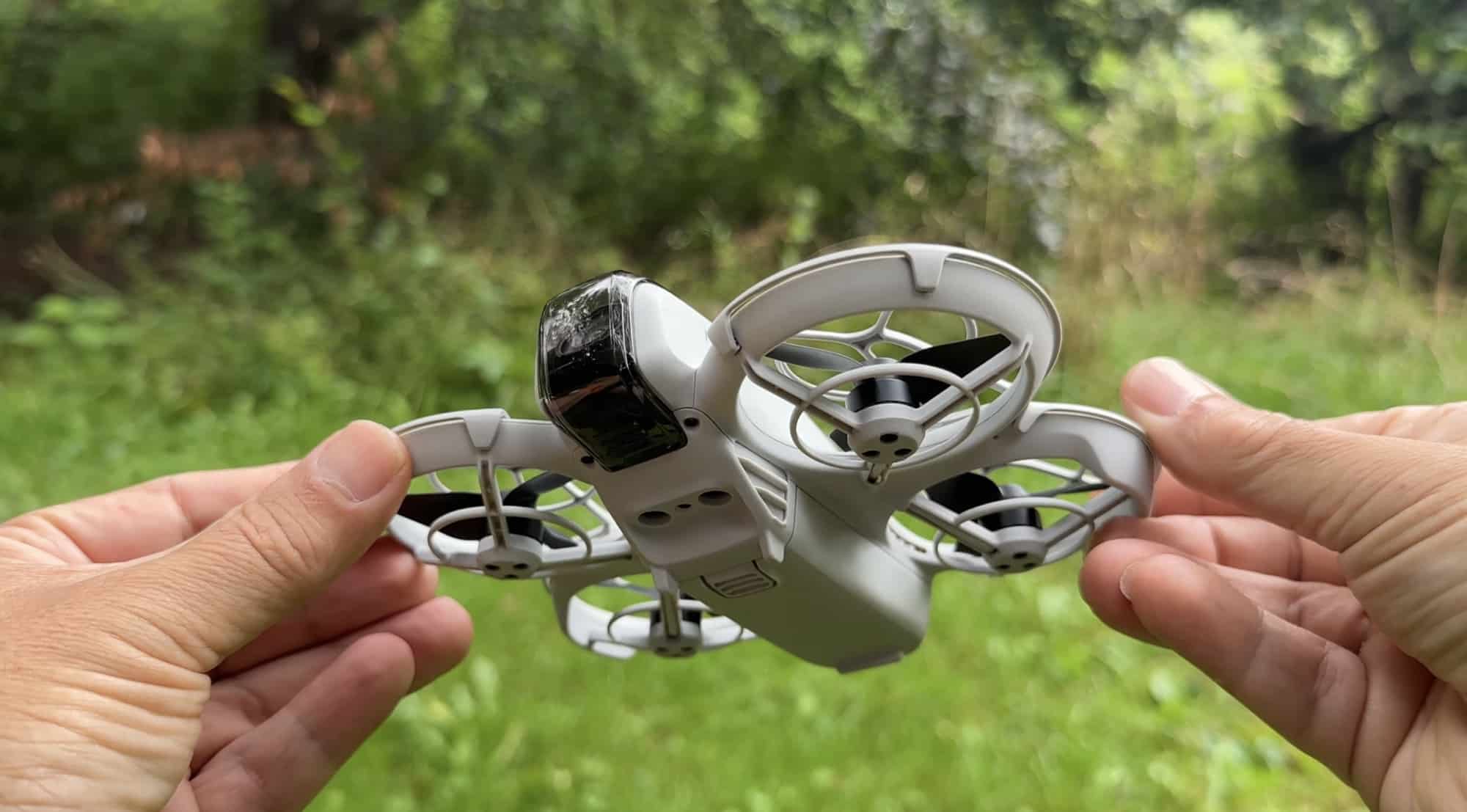 Larger DJI Avata 2 held in two hands for size reference outdoors.