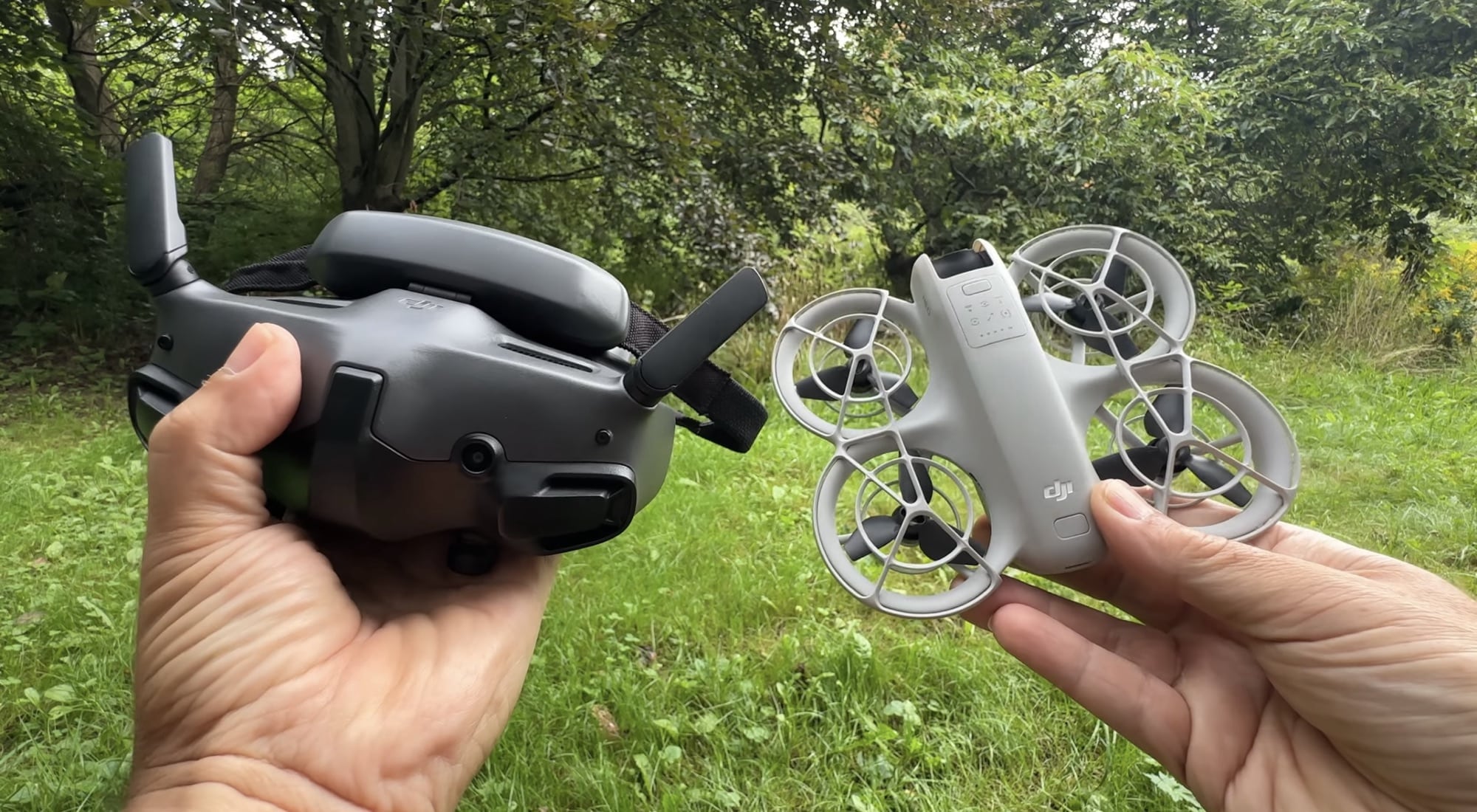 DJI Goggles 3 headset held up with the Neo alongside in the grass.