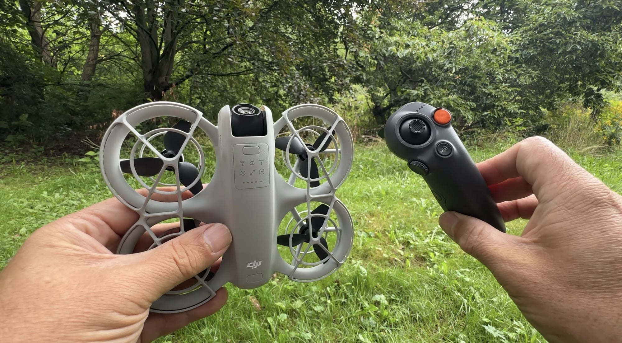 DJI Neo in one hand and the RC Motion 3 controller in the other.