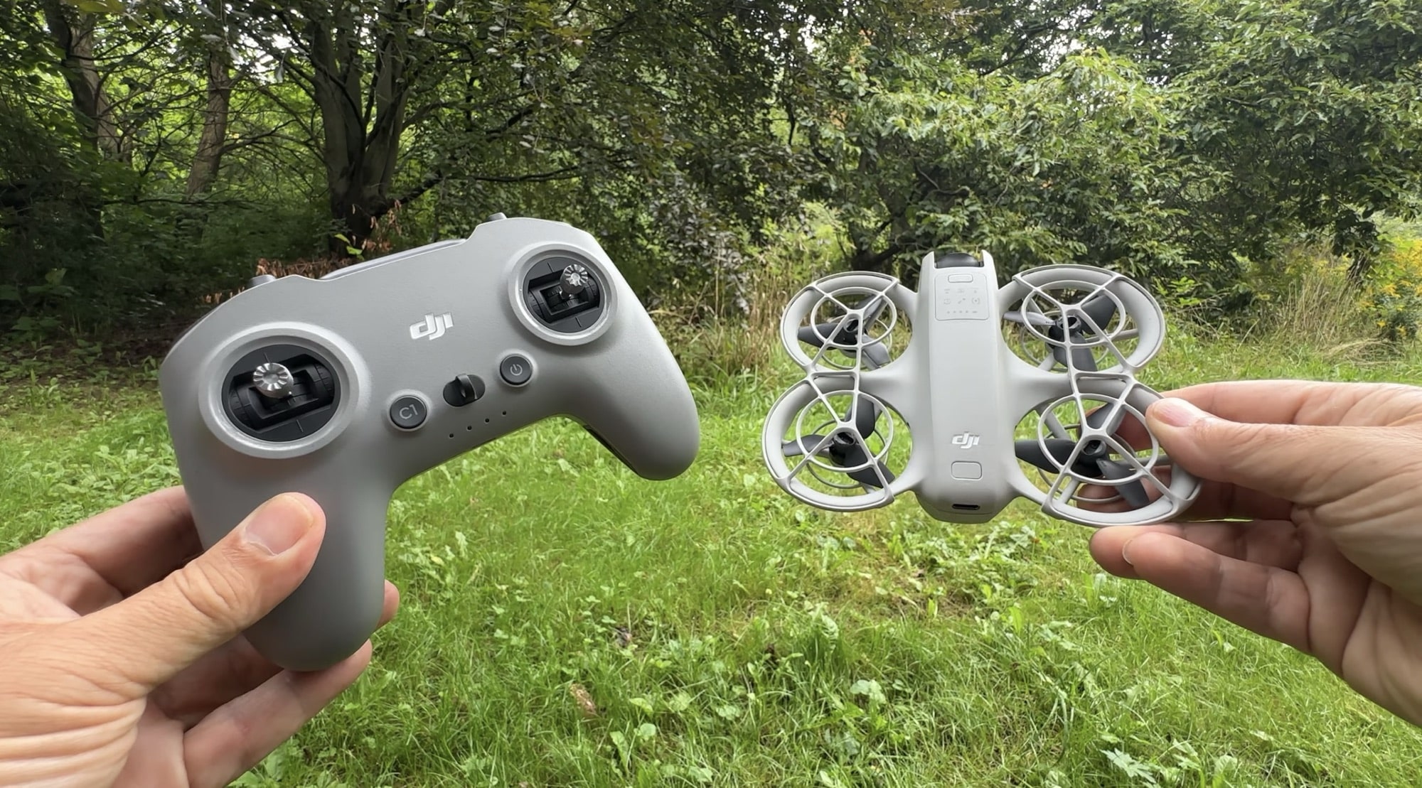 DJI FPV Remote Controller 3 held beside the compact Neo drone.