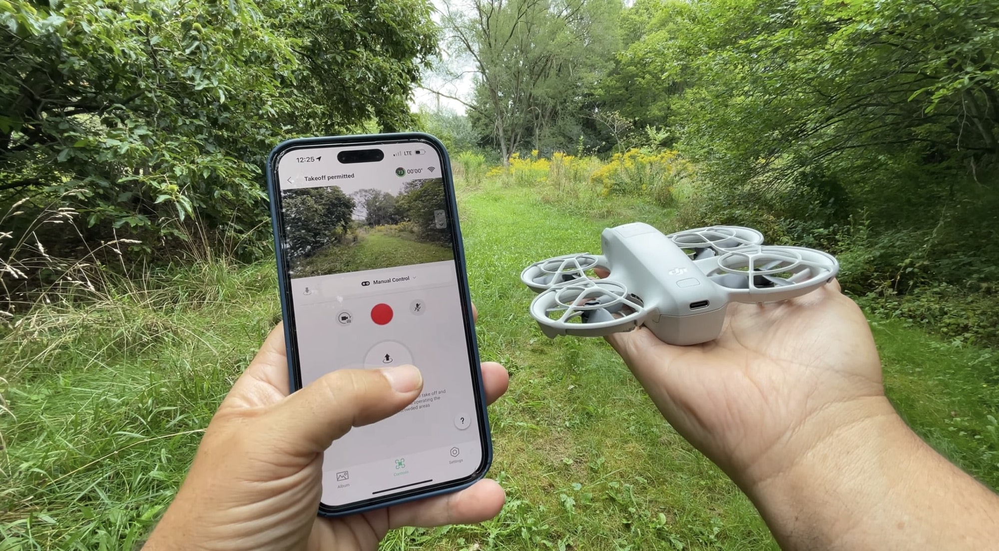Phone showing the DJI Fly manual control screen next to the Neo.