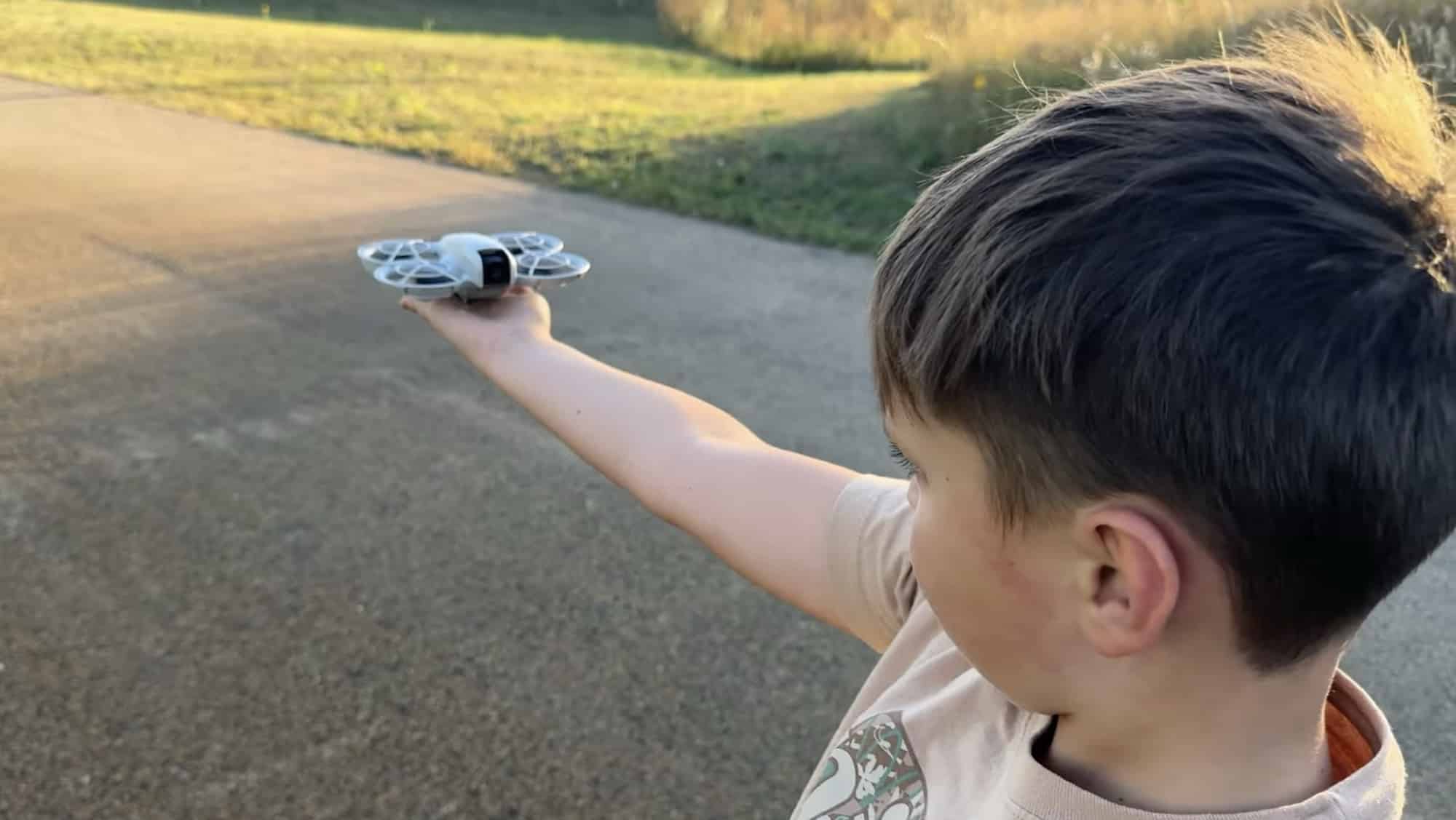 Close view over a boy's shoulder as the Neo hovers above his palm.