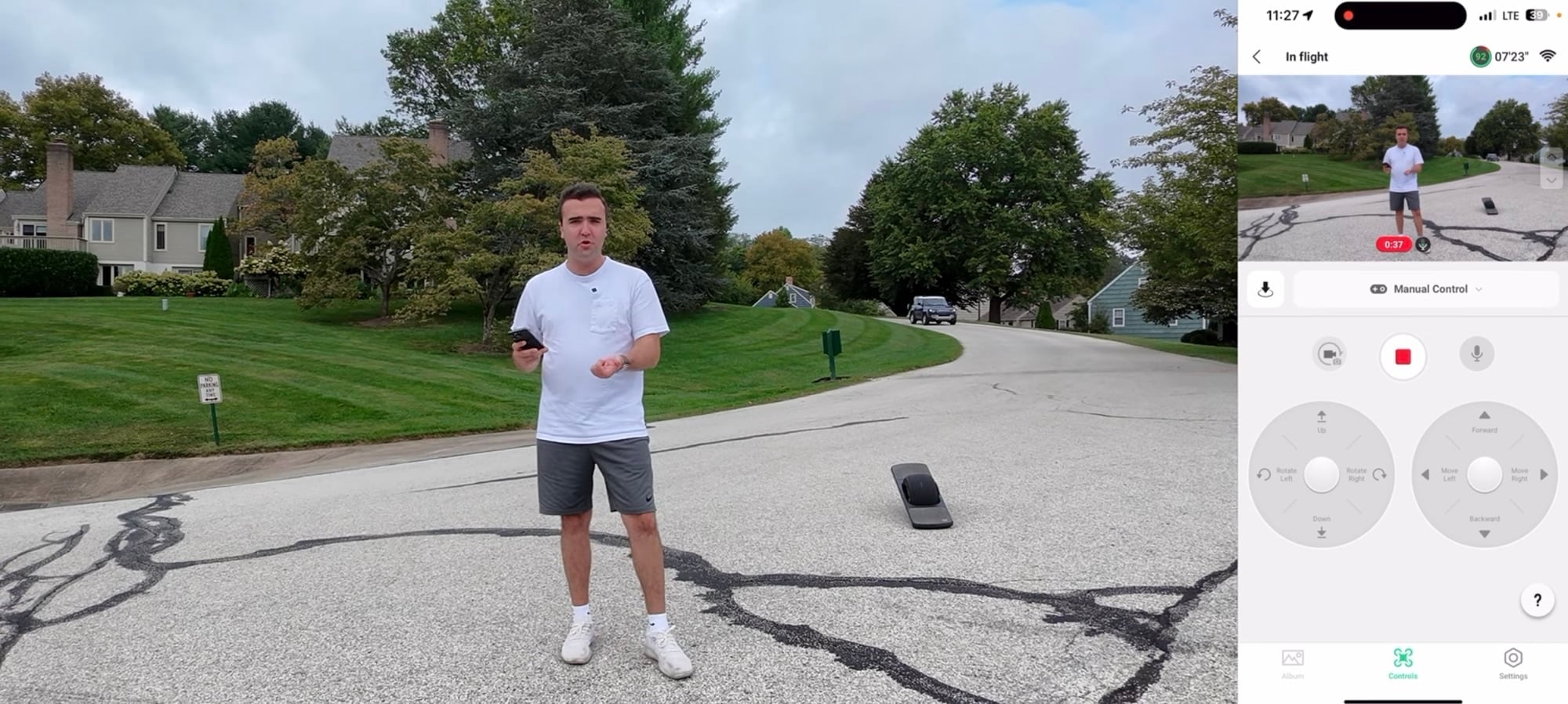 Pilot on a driveway with his phone beside the Neo and a manual control panel.