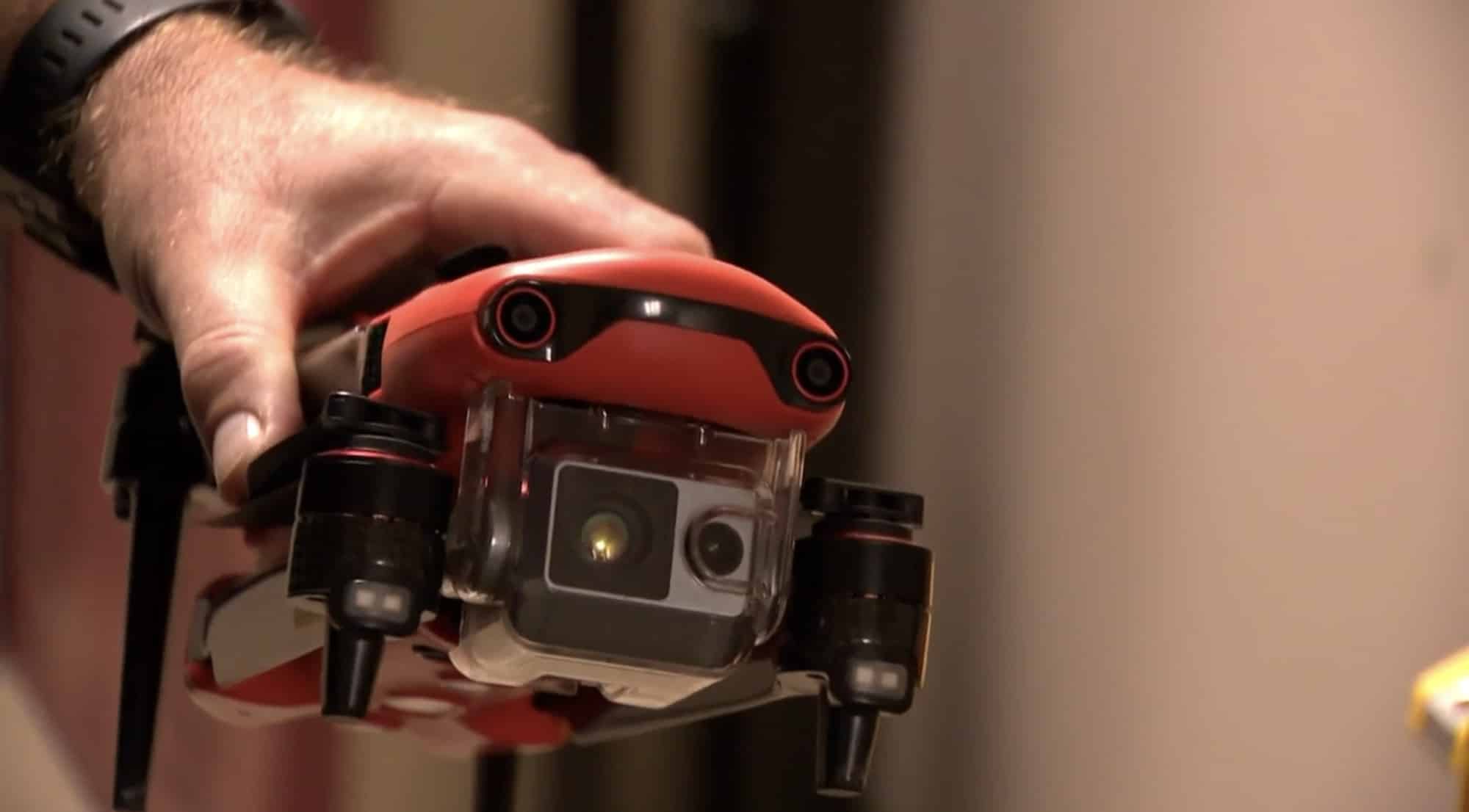 A Sumner County EMA operator lifts an orange thermal drone before launch.