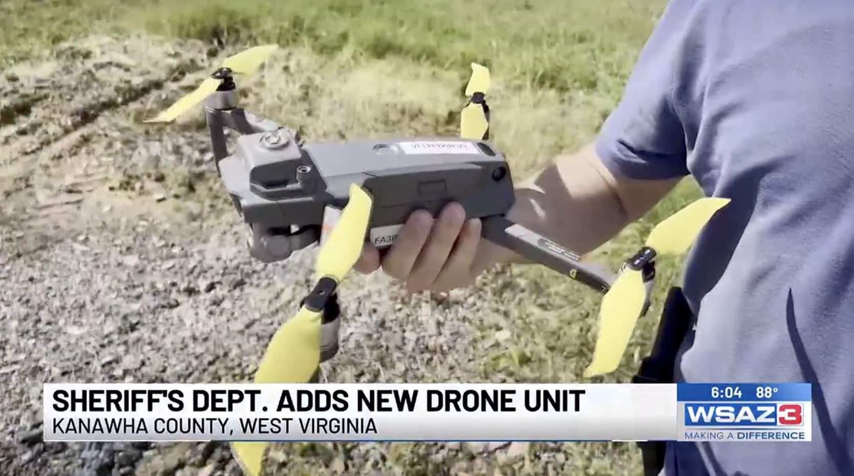 A deputy holding a DJI Mavic with yellow propellers in a news broadcast.