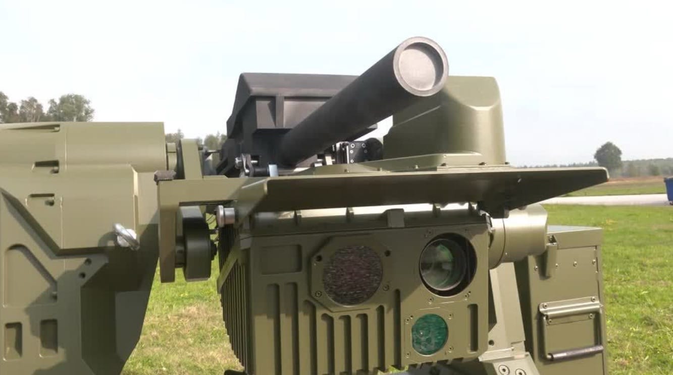 Olive-green counter-drone turret with a large barrel and optics mounted on a vehicle.