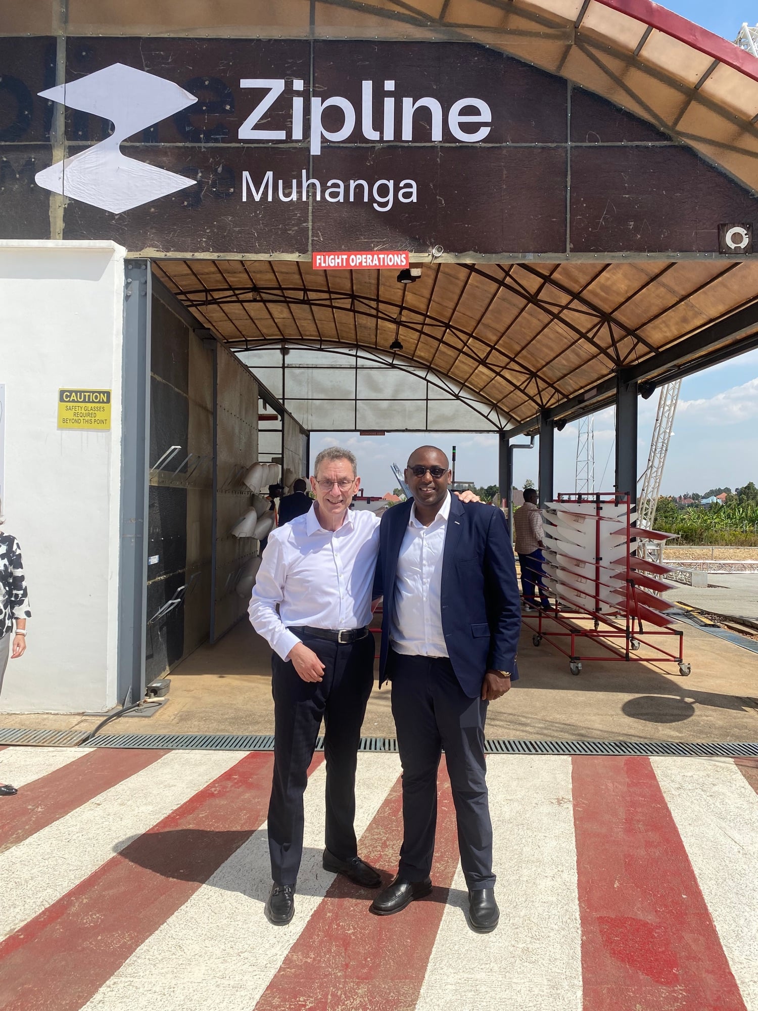 Two executives stand at the entrance of Zipline's Muhanga distribution center.