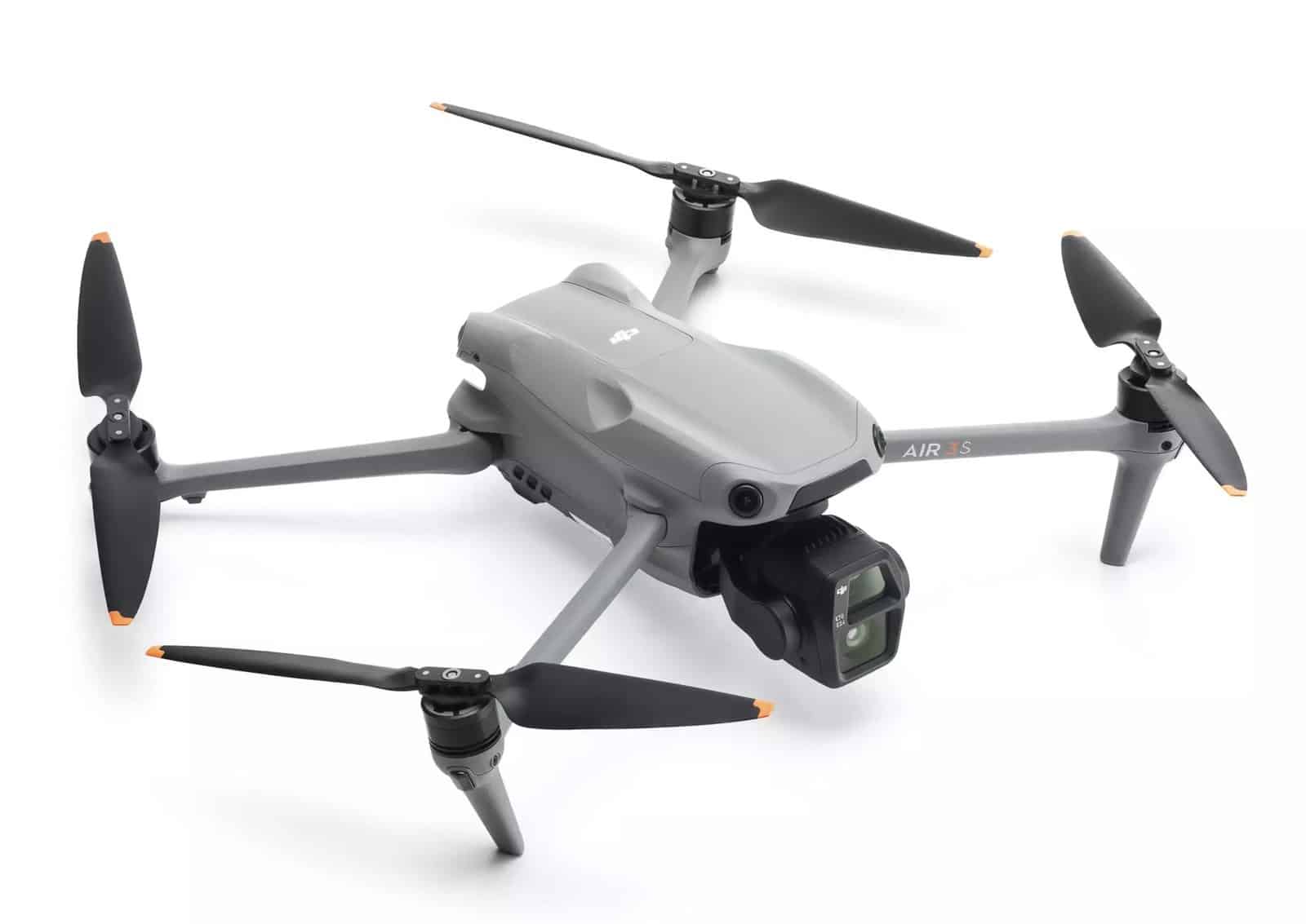 Raised three-quarter studio view of the unfolded quadcopter with orange-tipped blades.