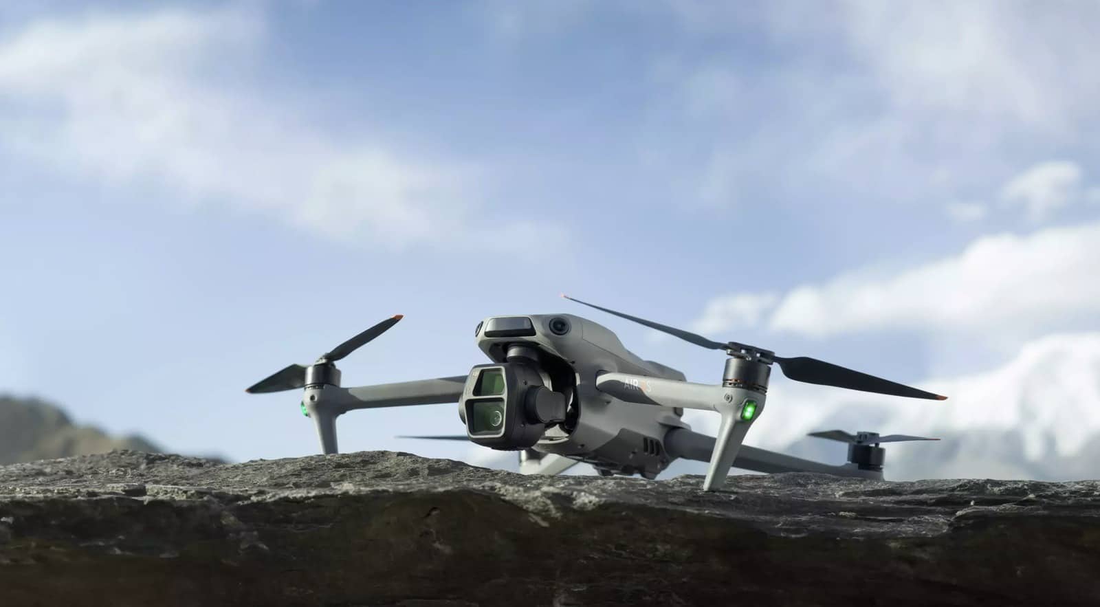 Air 3S parked on a rocky ledge above a lake, propellers unfolded.