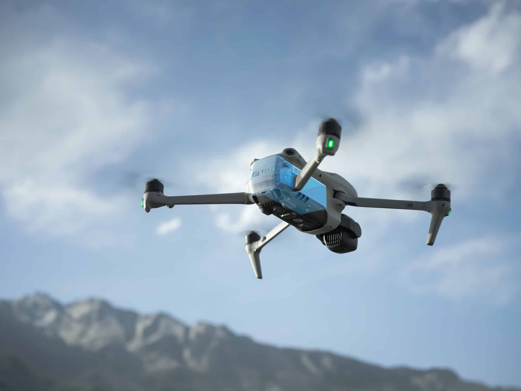 Air 3S banks against cloud above a snowy ridge, blue battery panel visible.