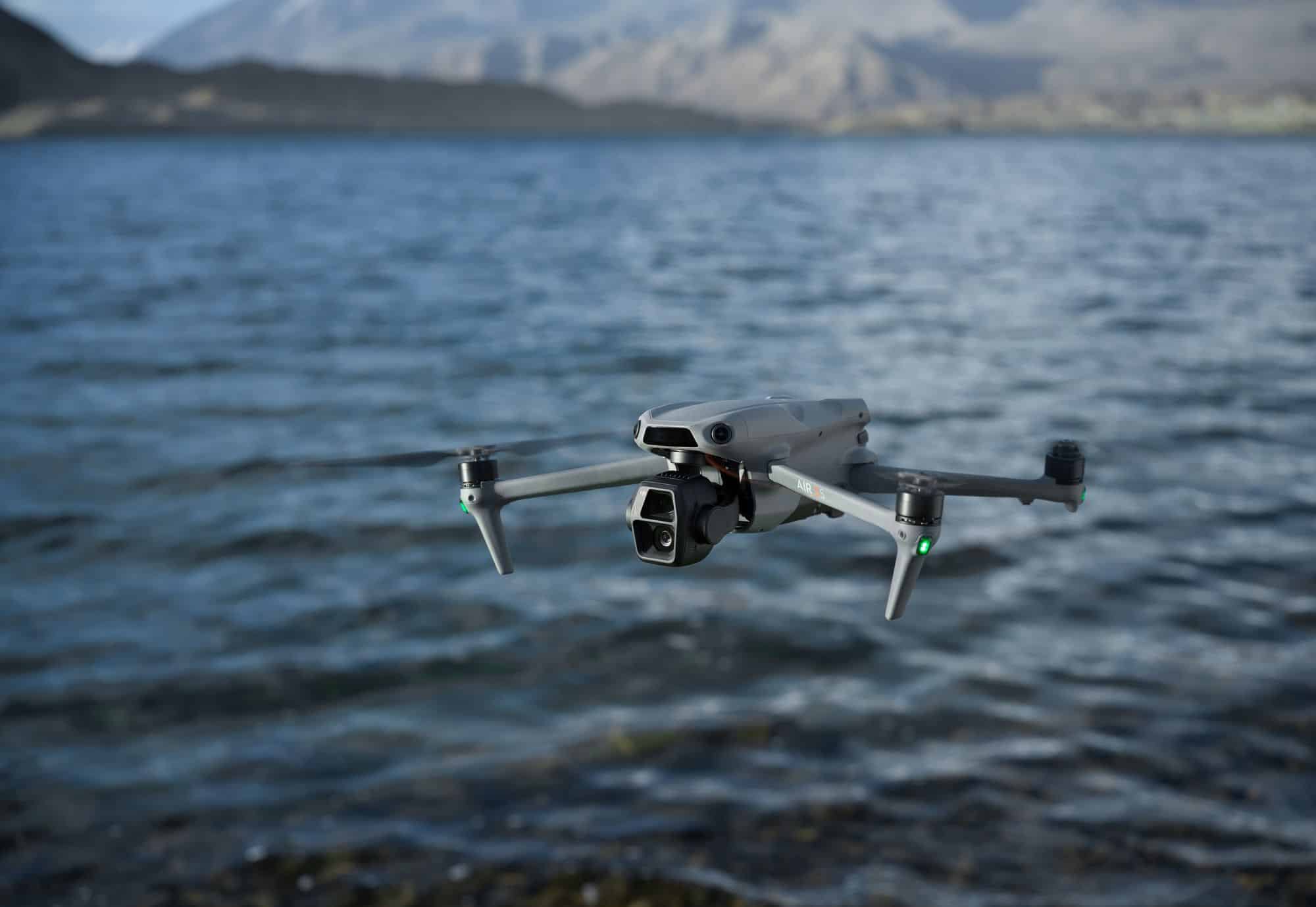 Air 3S hovering just above rippling lake water in side profile.