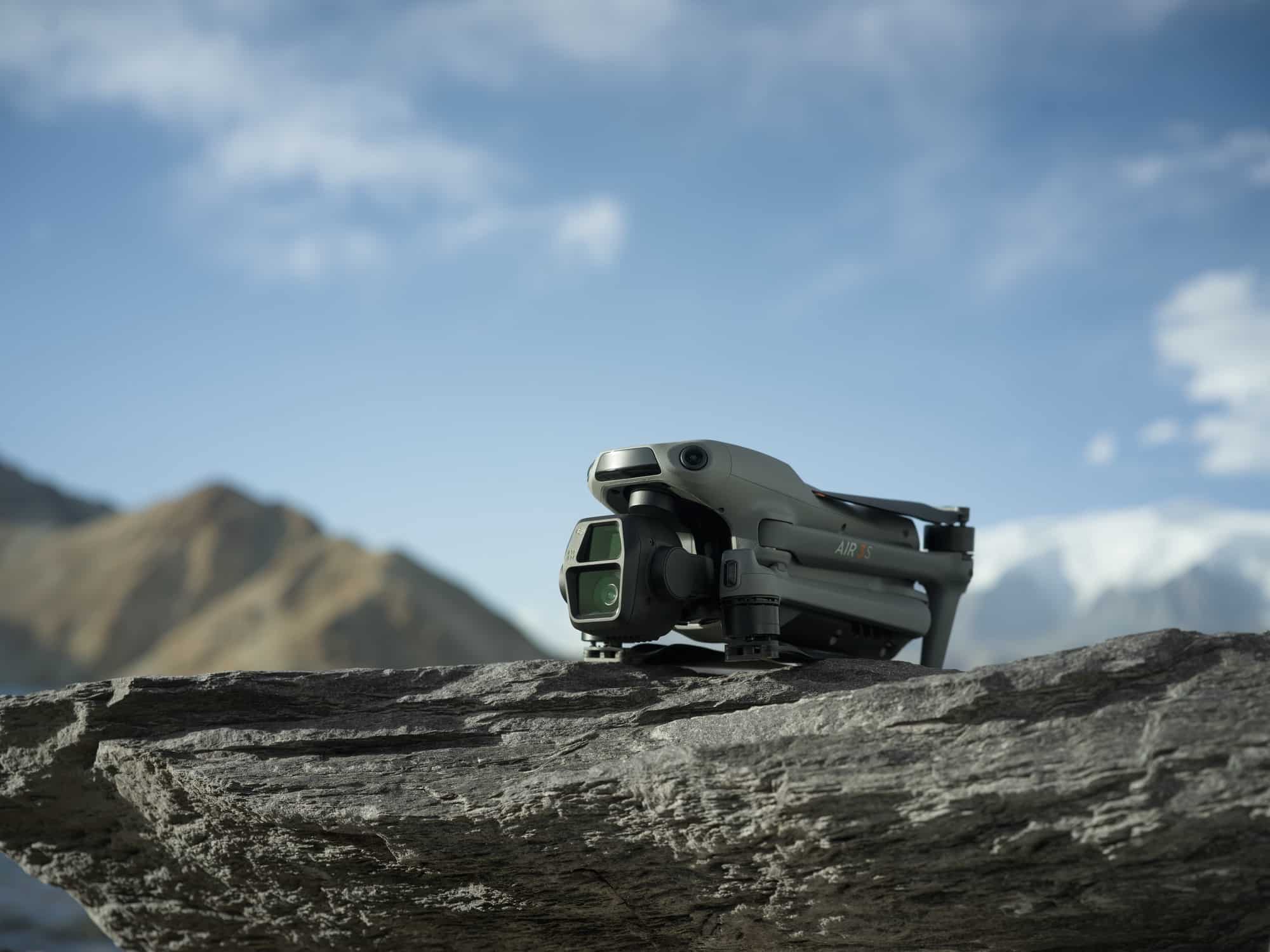 Folded Air 3S resting on a rocky ledge with mountains blurred behind.