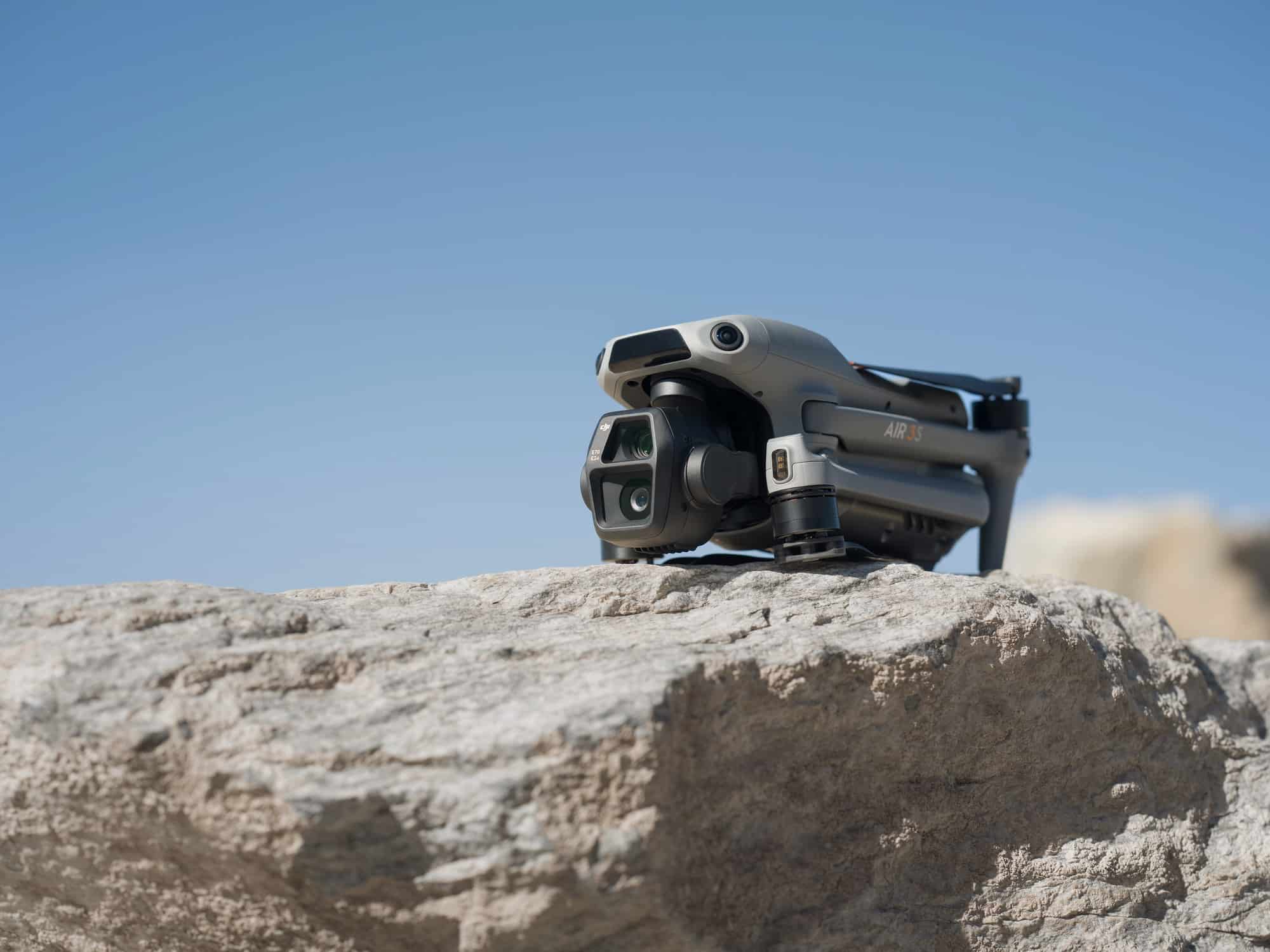 Folded Air 3S perched on a pale rock ledge against a clear blue sky.