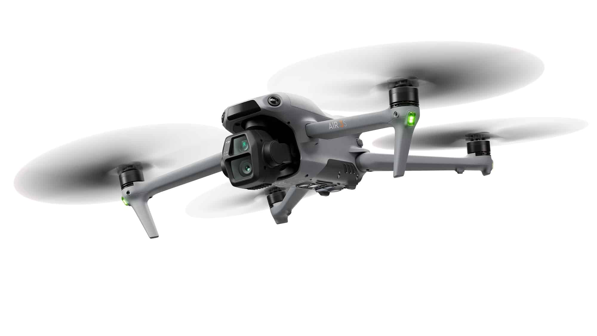 Air 3S in a studio shot with its propellers spinning and status light green.