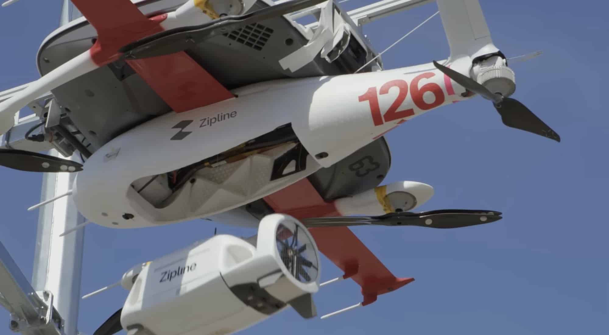 Zipline delivery aircraft numbered 126 suspended on an indoor test rig.