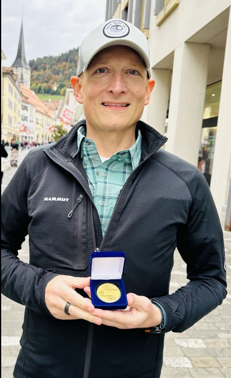 Romeo Durscher holds his Golden Medal outdoors after the award ceremony.