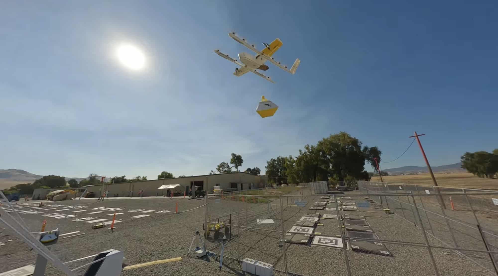 Wing delivery aircraft hovering over the drop zone with its payload attached.