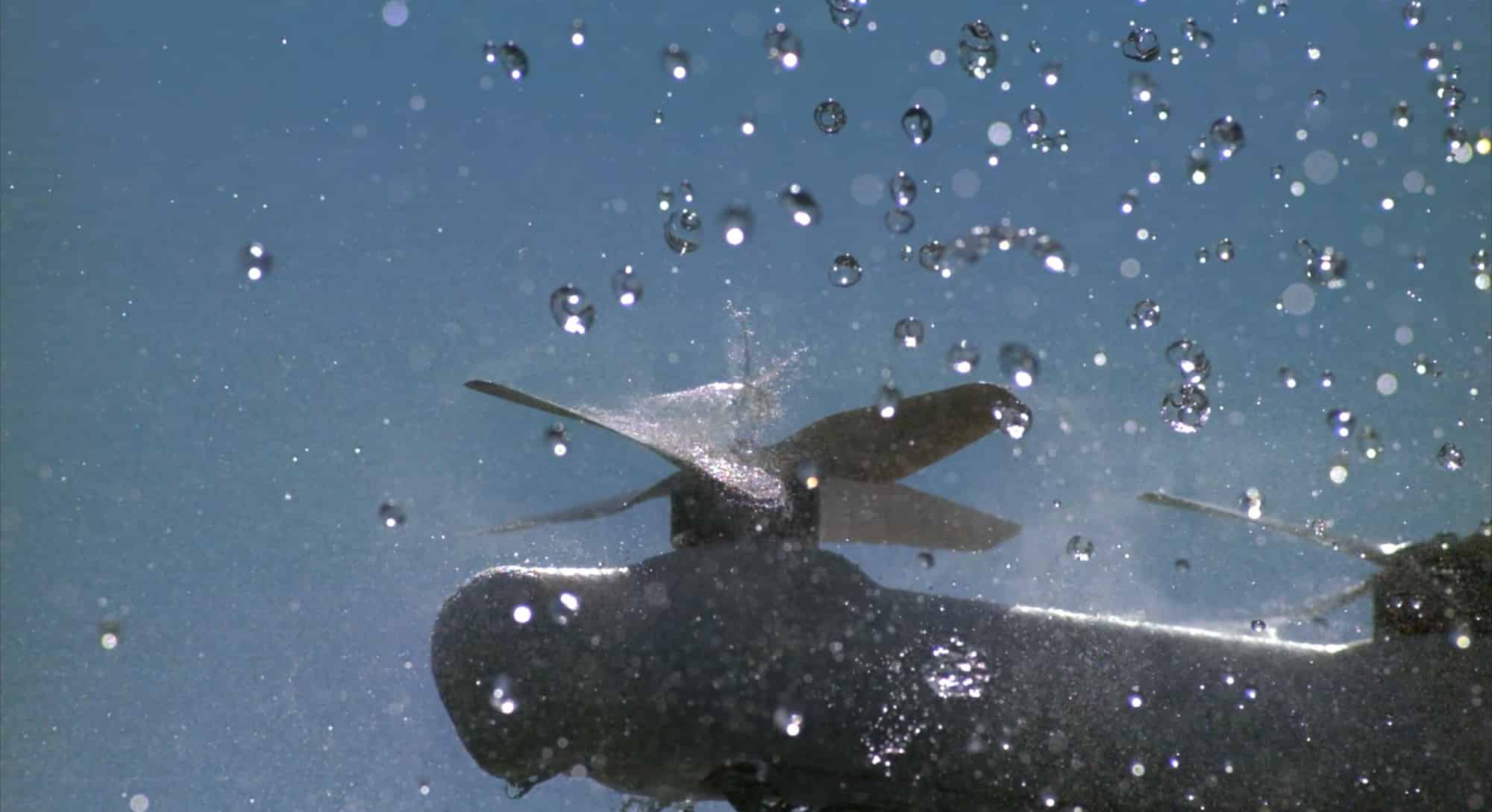Wing delivery aircraft holding position through simulated rain in weather resilience testing.