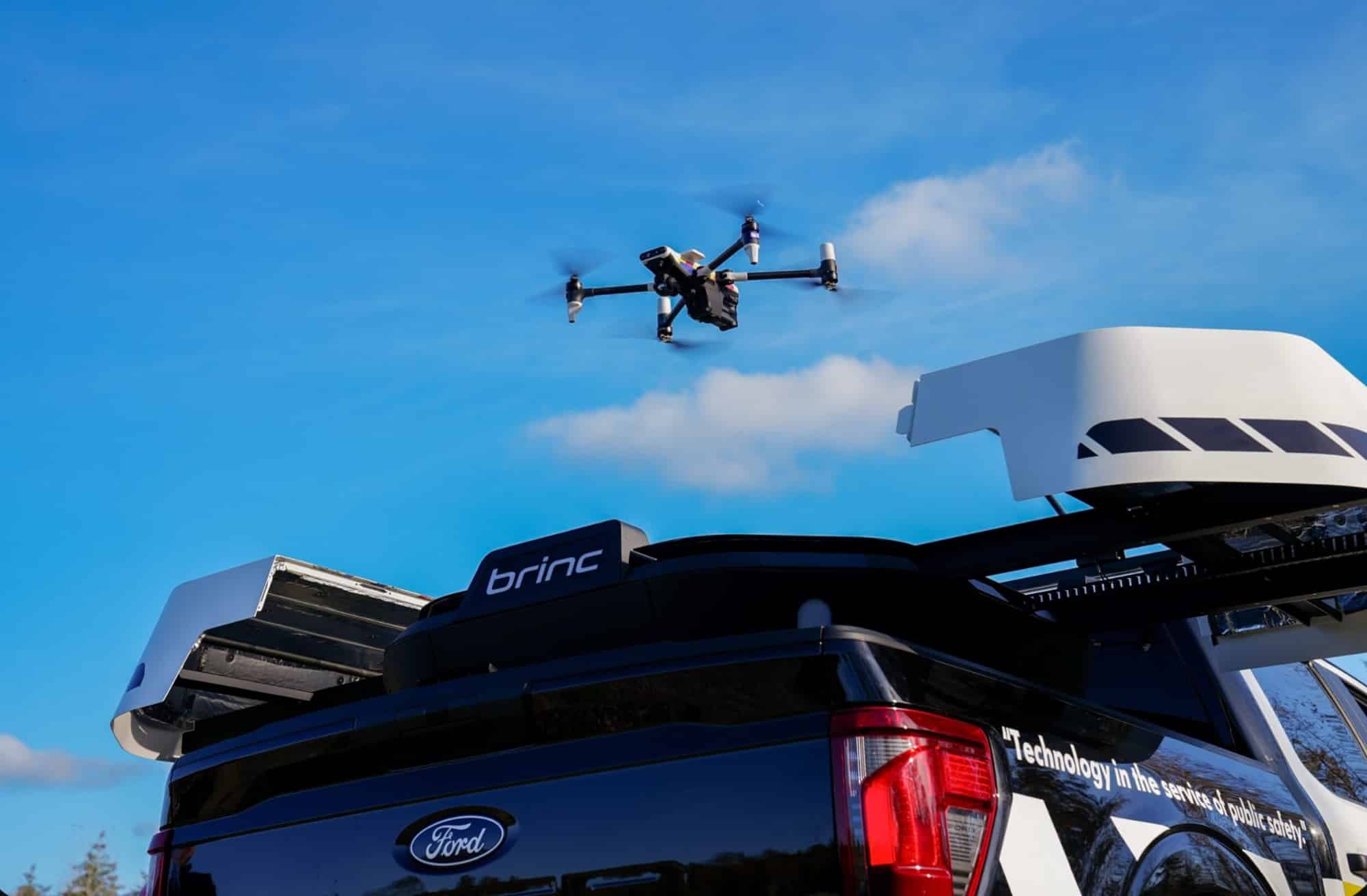 BRINC charging nest mounted on a pickup truck with a drone overhead.