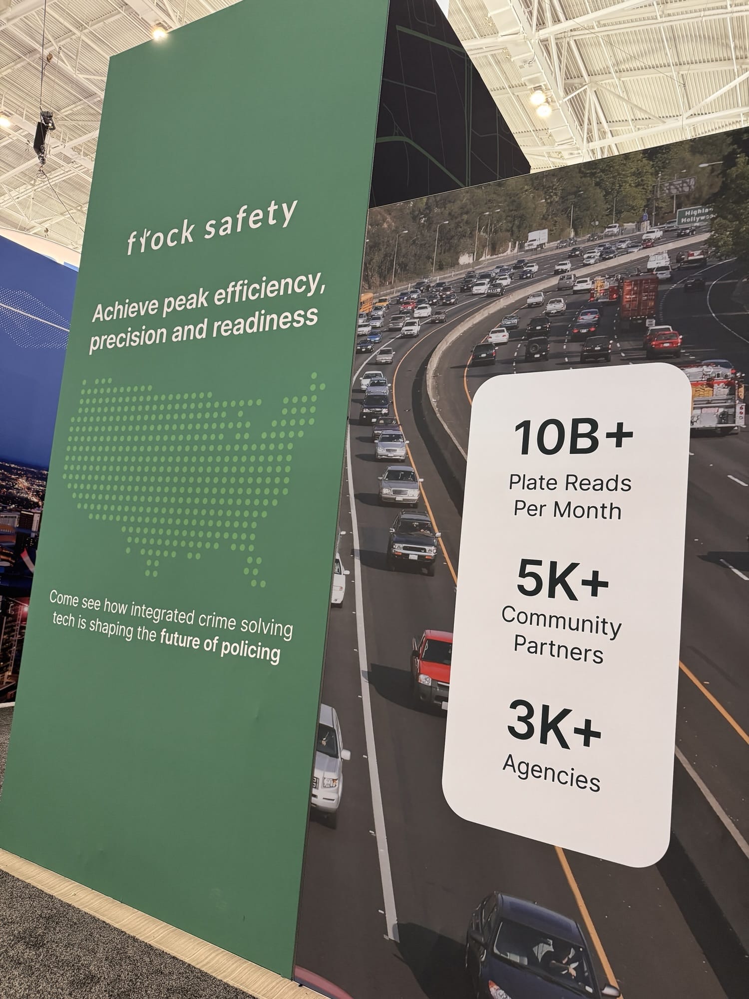 Flock Safety conference booth banner listing plate reads, partners and agency counts.