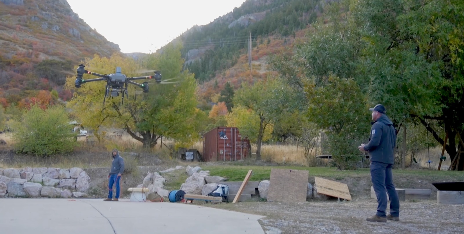 DJI FlyCart 30 lifting off from a canyon staging area as crew watch.
