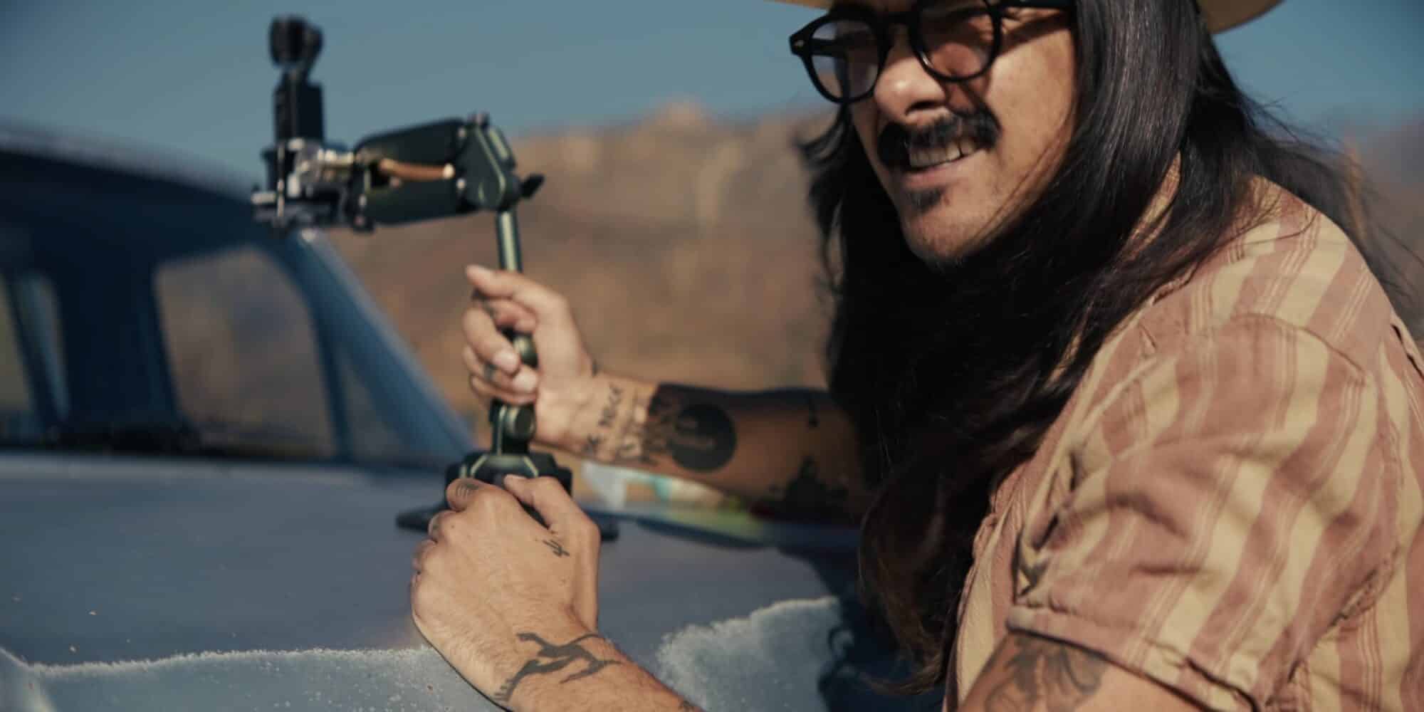 Man clamping a DJI Pocket 3 on the Tilta Hydra Mini to a car window.