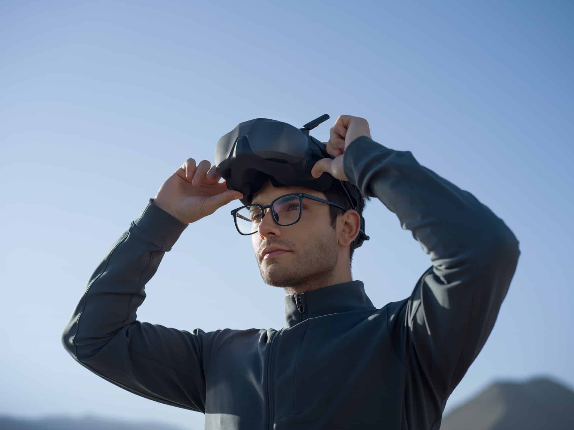 Man in prescription glasses lifting the Goggles N3 onto his forehead outdoors.
