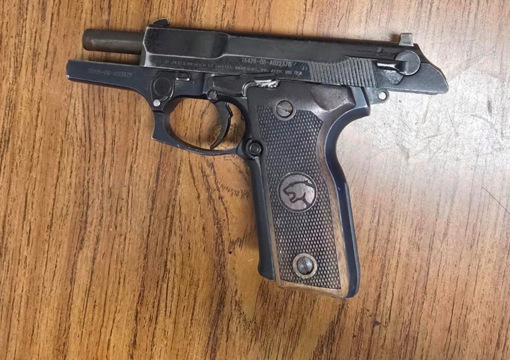 Pistol recovered by police lying on a wooden tabletop.