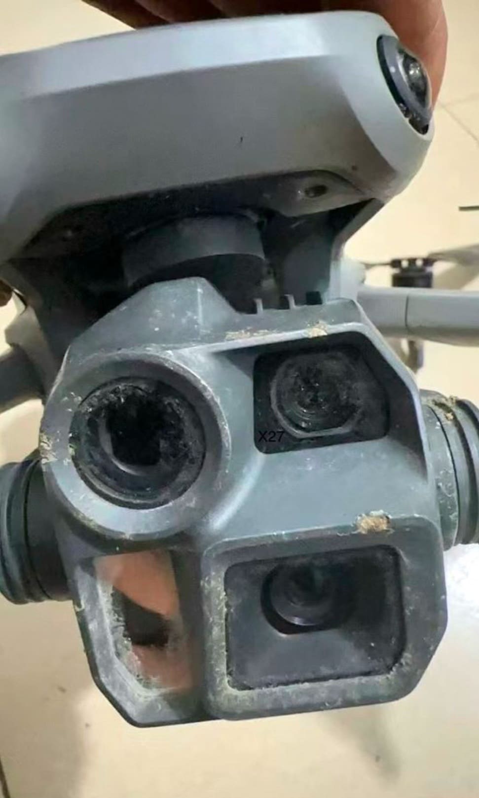 Close-up of a scuffed triple-lens gimbal on the crashed enterprise prototype.
