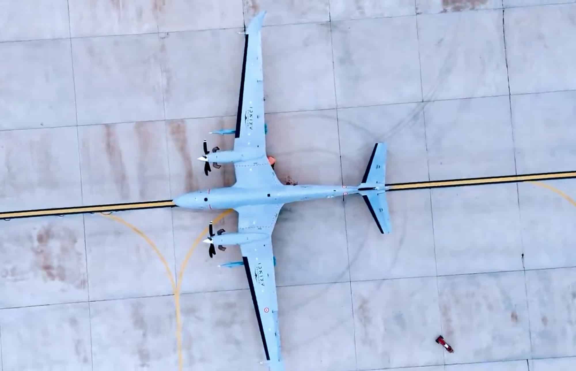 Overhead view of a pale blue Bayraktar Akinci combat drone on a concrete apron.