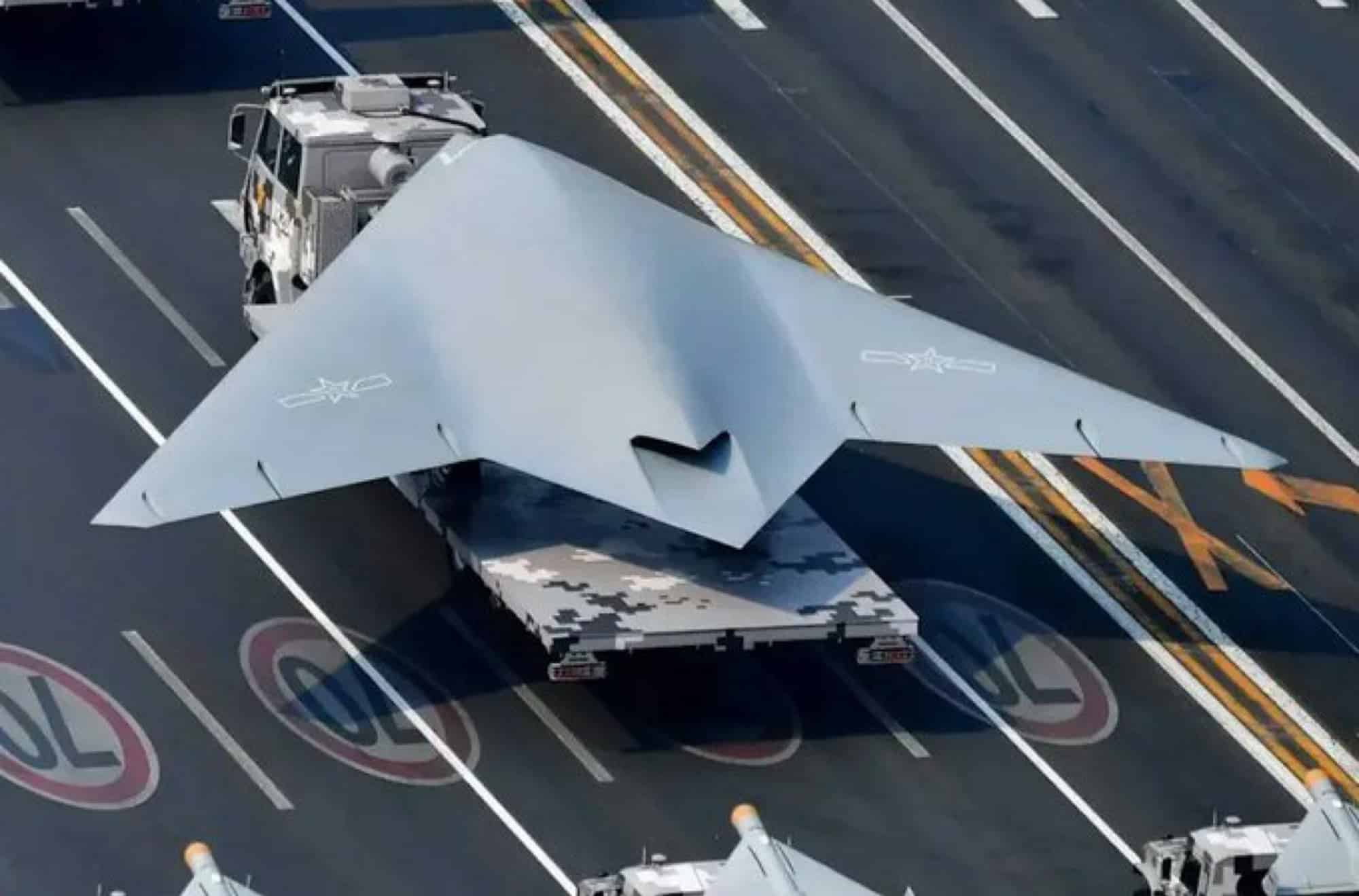 Overhead view of a grey flying-wing stealth drone parked on a runway.