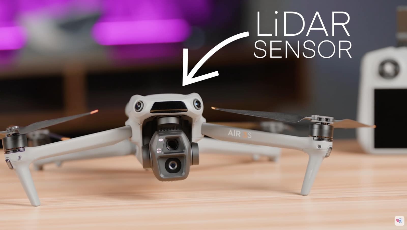 DJI Air 3S on a desk with an arrow labeling its forward lidar sensor.