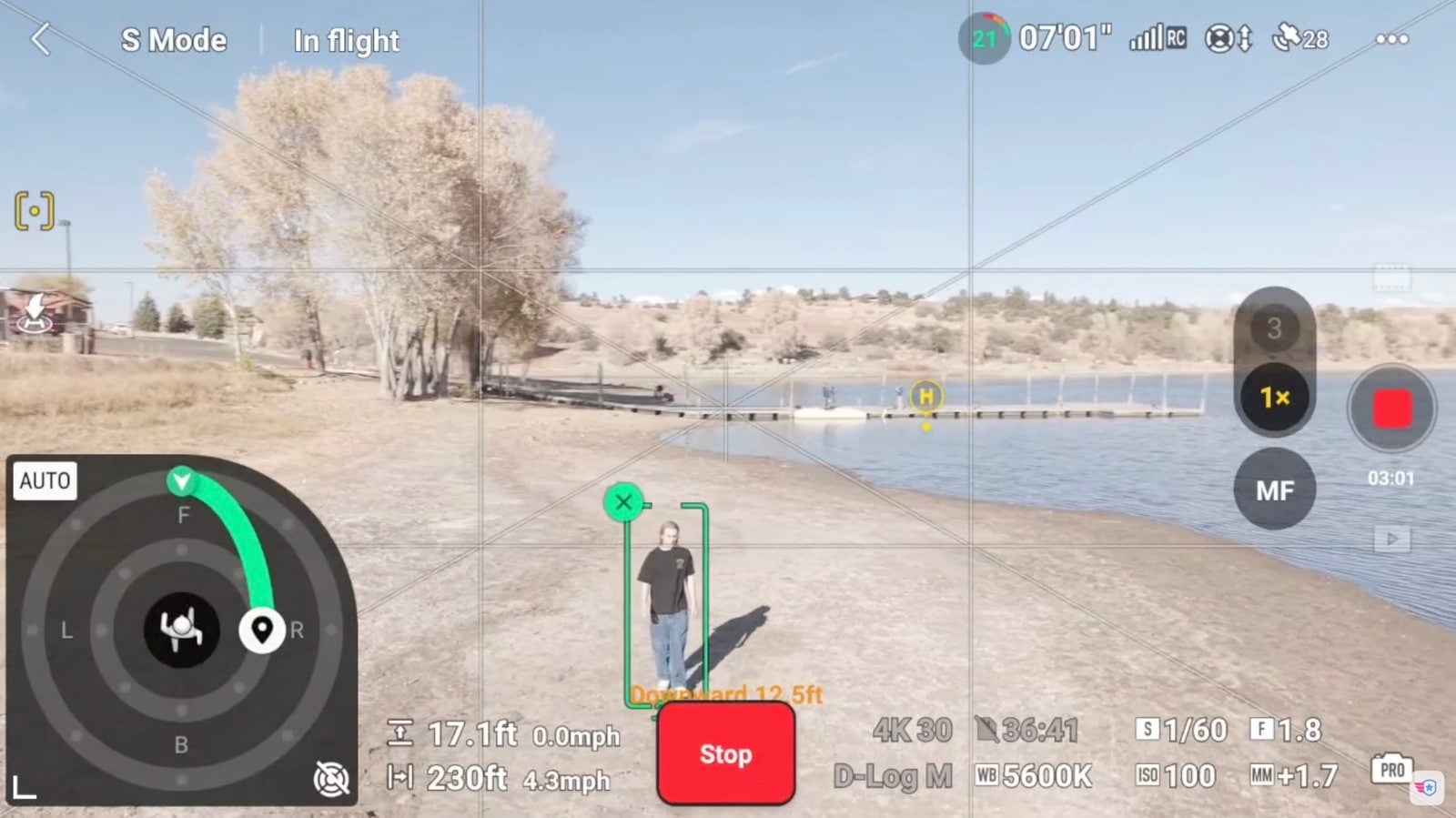 Screenshot of the DJI Fly tracking view following a person beside a reservoir.
