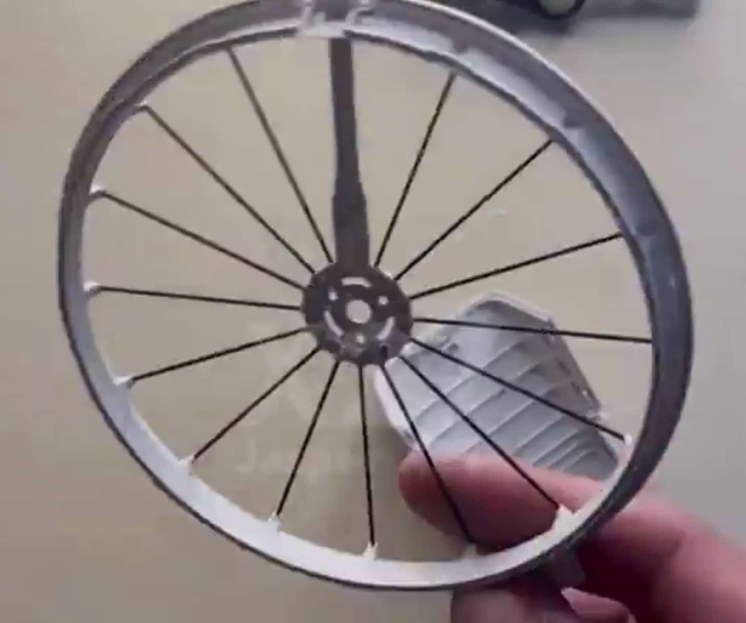 Hand holding a leaked wheel-shaped propeller duct from a DJI prototype.
