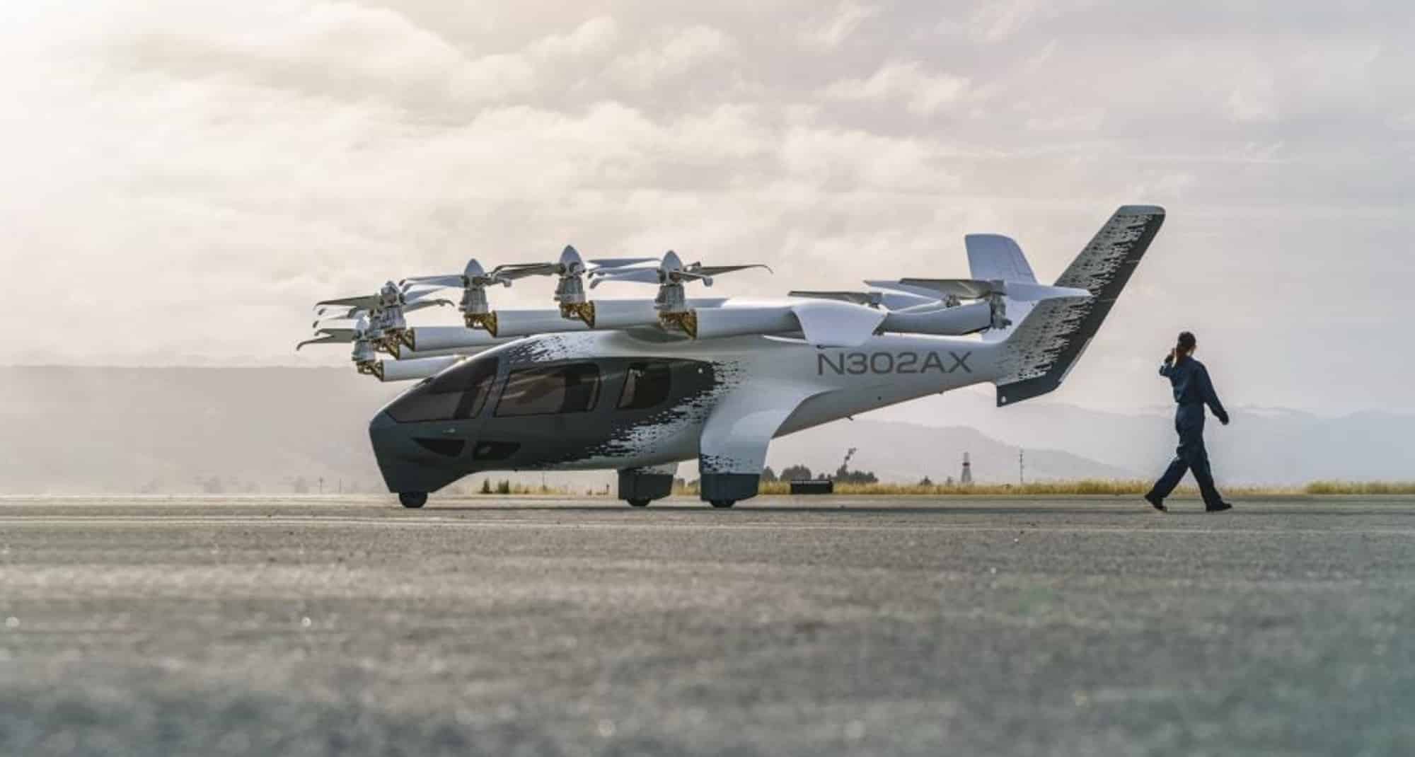 Archer's Midnight eVTOL, registration N302AX, sits on a runway as a person walks past.
