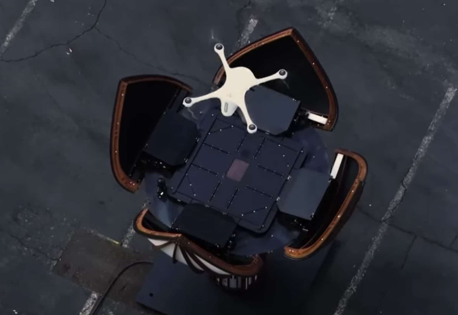 Overhead view of a white Matternet delivery drone atop an open landing station.