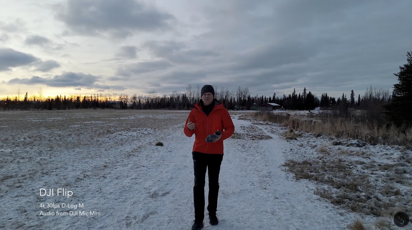 Man in a red parka walking a snowy road at sunset, recorded with Mic Mini.