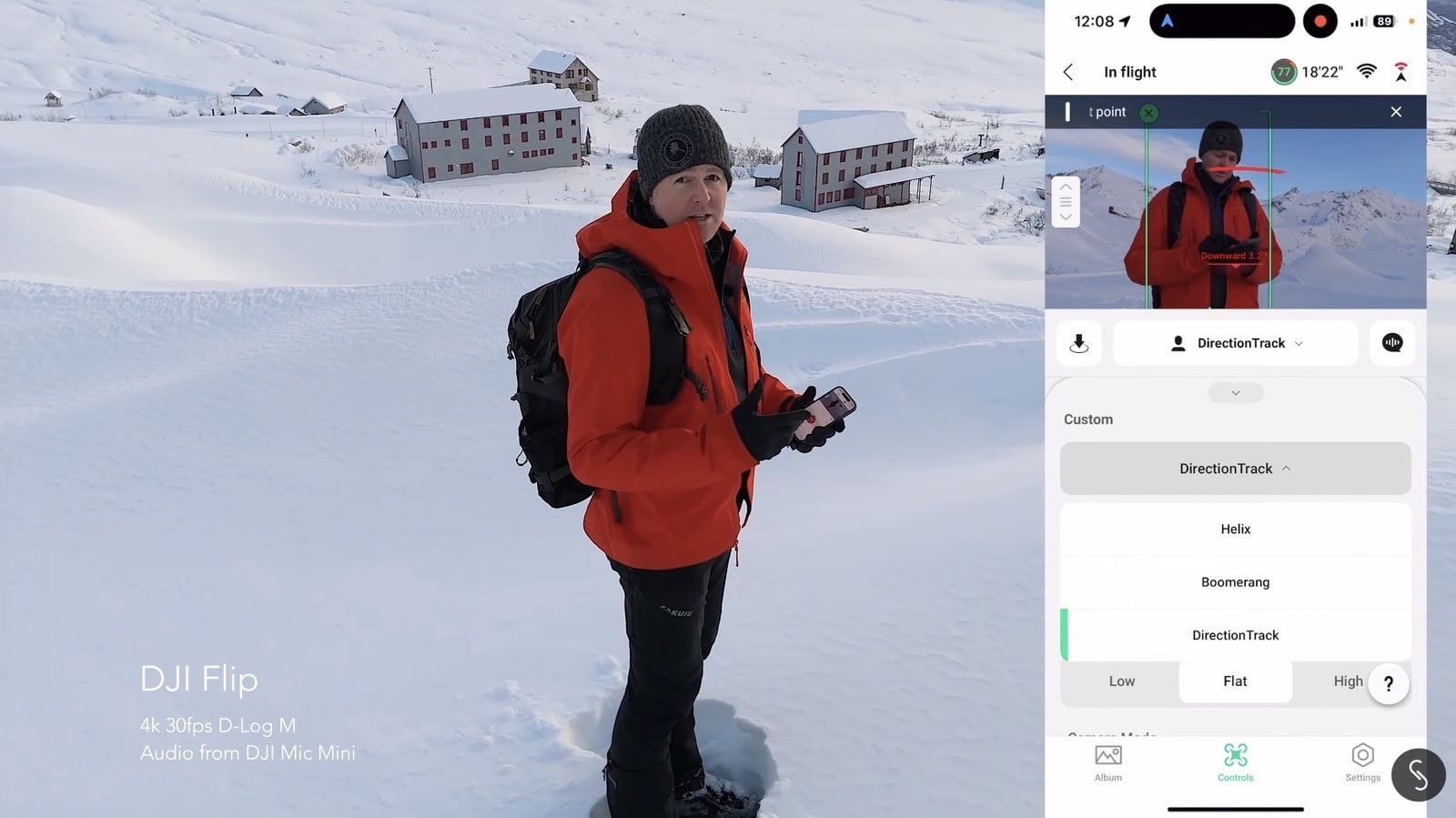 Pilot with the remote beside snowy buildings next to a DirectionTrack app panel.