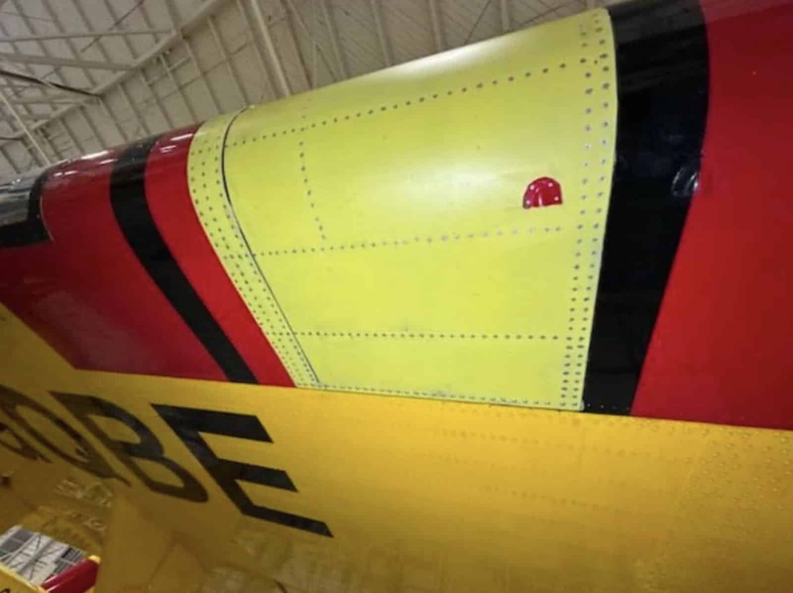A yellow-primed replacement panel fitted beside the aircraft black registration lettering.