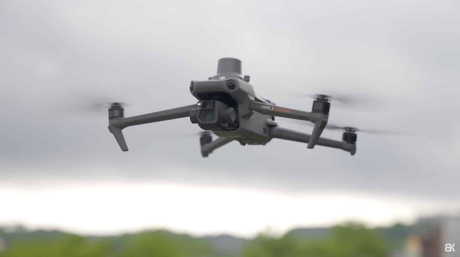 A DJI Mavic 3 Enterprise hovers against a flat overcast sky.