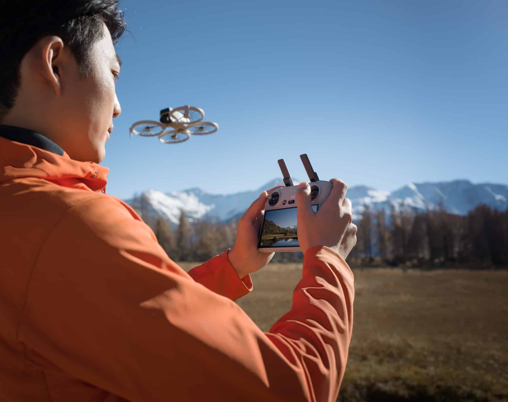 Man in an orange jacket flying the Flip using the DJI RC 2.